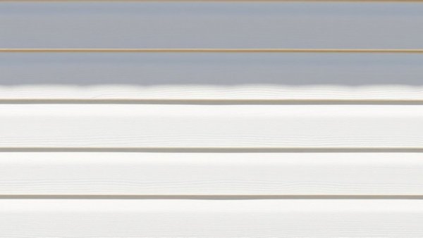 Close-up of textured white siding with shadow highlighting quality.