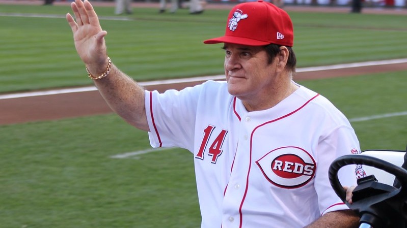 Older man in red baseball uniform in dugout, gambling on baseball context
