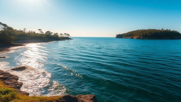 Serene coastal view with sparkling water and distant shoreline.