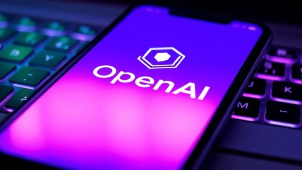 Close-up of OpenAI logo on smartphone over glowing keyboard, AI impact on jobs.