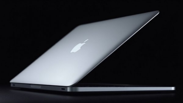 Sleek MacBook Ultra with half-open display against dark backdrop.