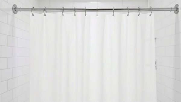 Pristine shower curtain liner on rod in modern bathroom.