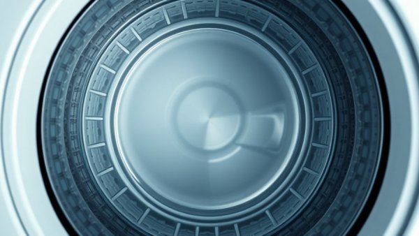 Shiny washing machine drum in a top-down view.