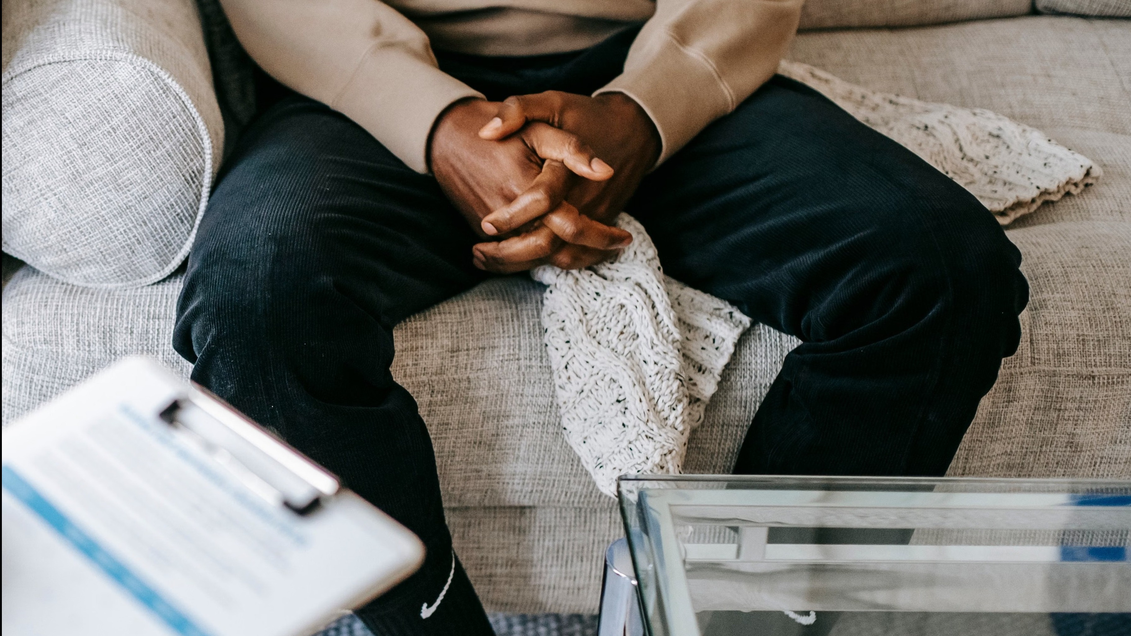 thoughtful addiction counseling session, reassuring, listening attentively to a client, photorealistic, modern office with abstract art, highly detailed, subtle interaction nuances, expertly captured, minimalistic colors, focused artificial lighting, shot with a portrait lens.