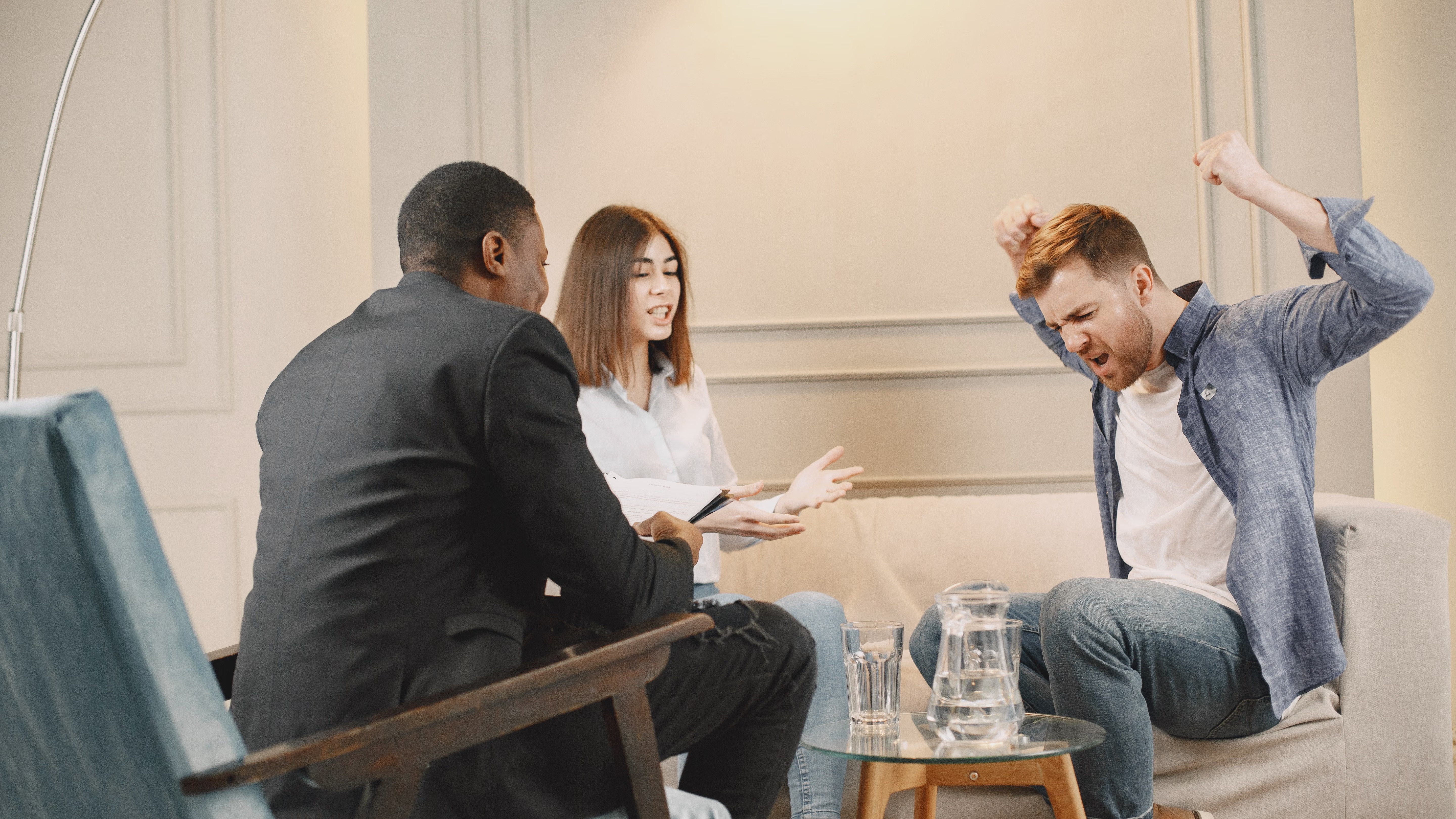 empathetic addiction therapy leader, encouraging, facilitating a mindfulness exercise, photorealistic, calming studio with cushioned floor, highly detailed, people in meditative poses, beautifully detailed, muted earth tones, soothing ambient lighting, shot with a 50mm lens.