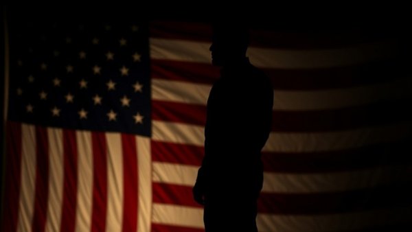 Silhouette with US flag reflects impact of US politics on travel.