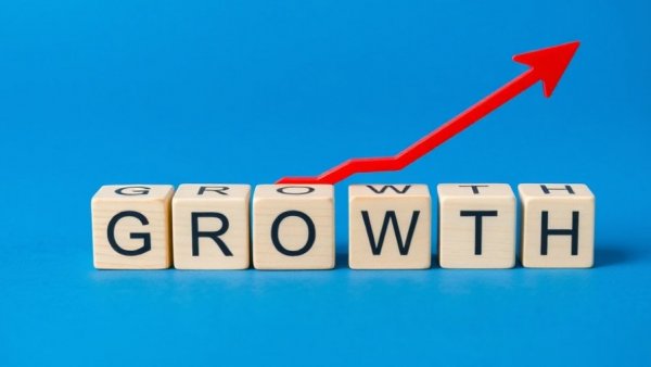 Wooden blocks with 'GROWTH' and arrow symbolizing business expansion.
