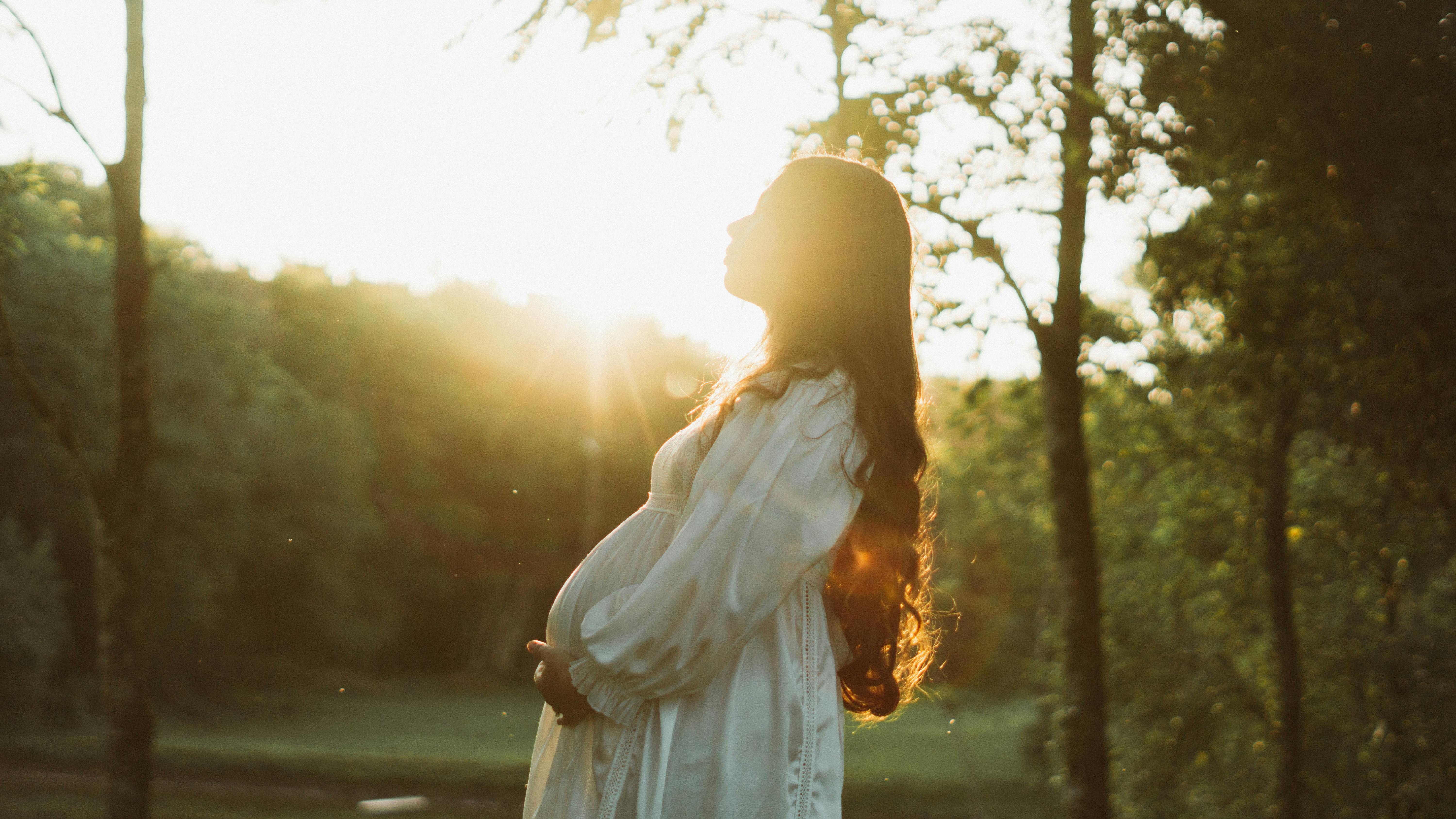 Pregnant woman in fall and winter maternity dress outdoors