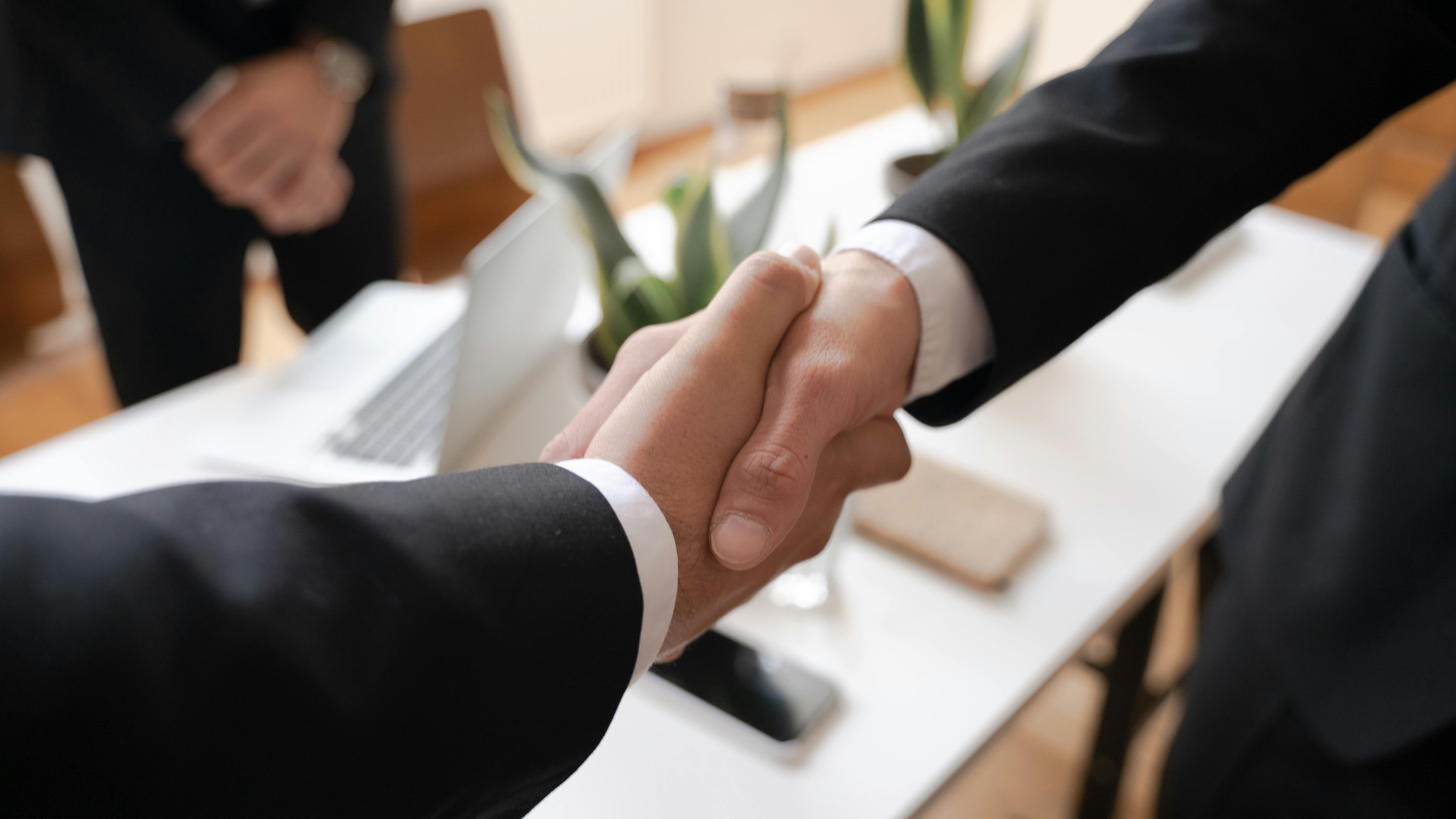 Handshake in business setting symbolizing salary negotiation.