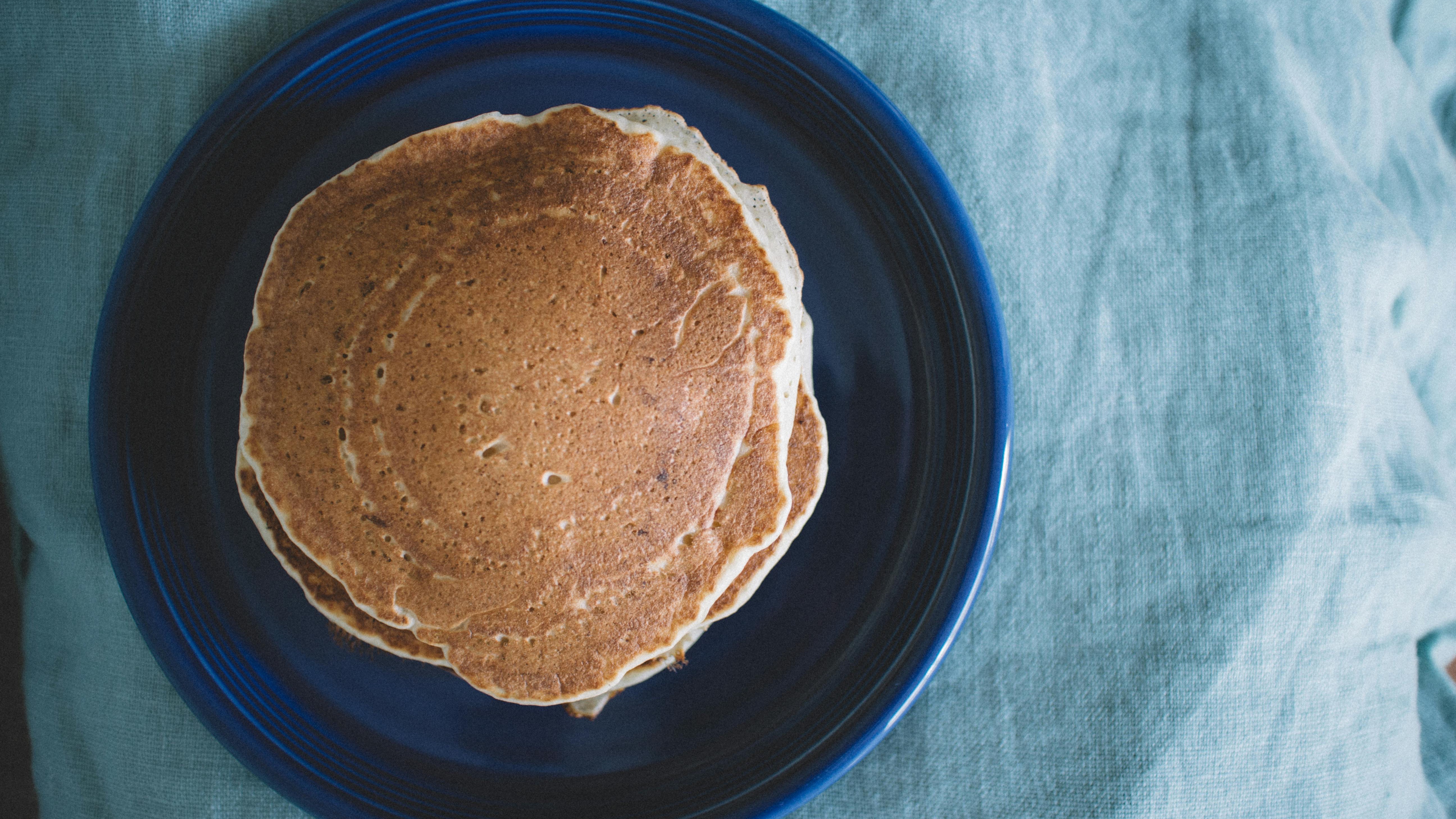 Fluffy strawberry pancakes with fresh strawberries on a plate.
