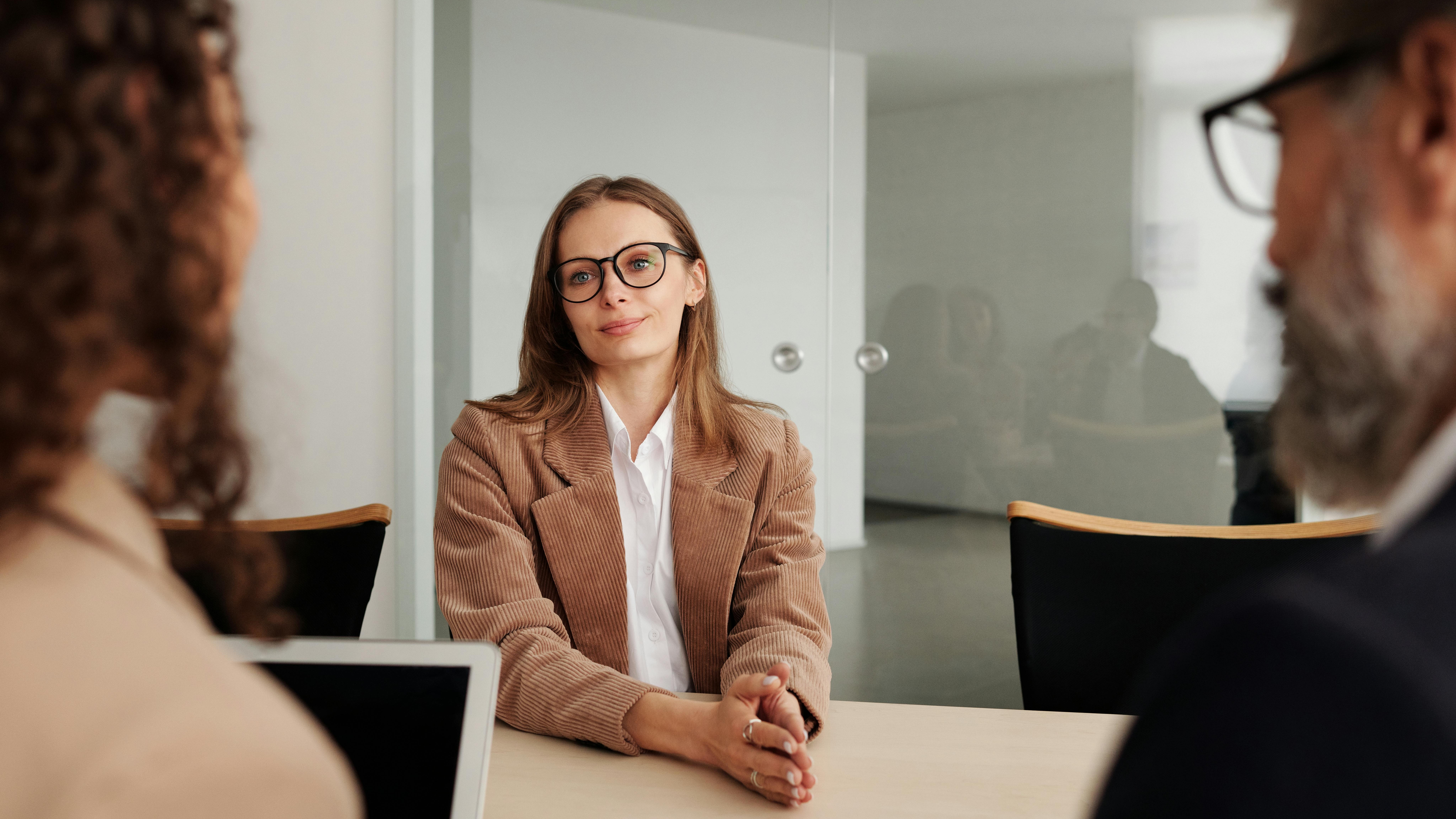 Professional woman using laptop in modern office, embracing generative AI in recruiting.
