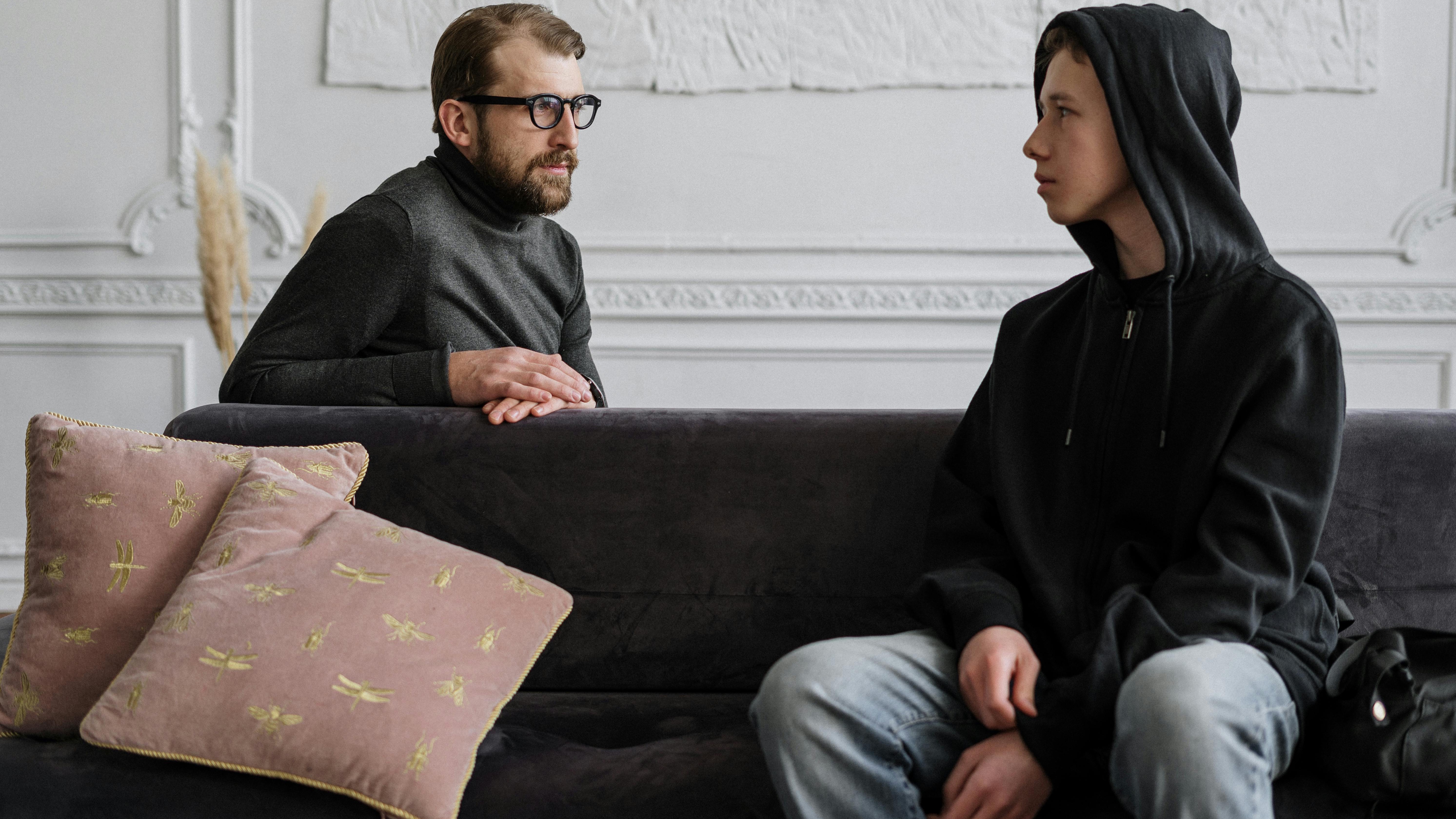 Teenage communication scene with thoughtful boy in focus.