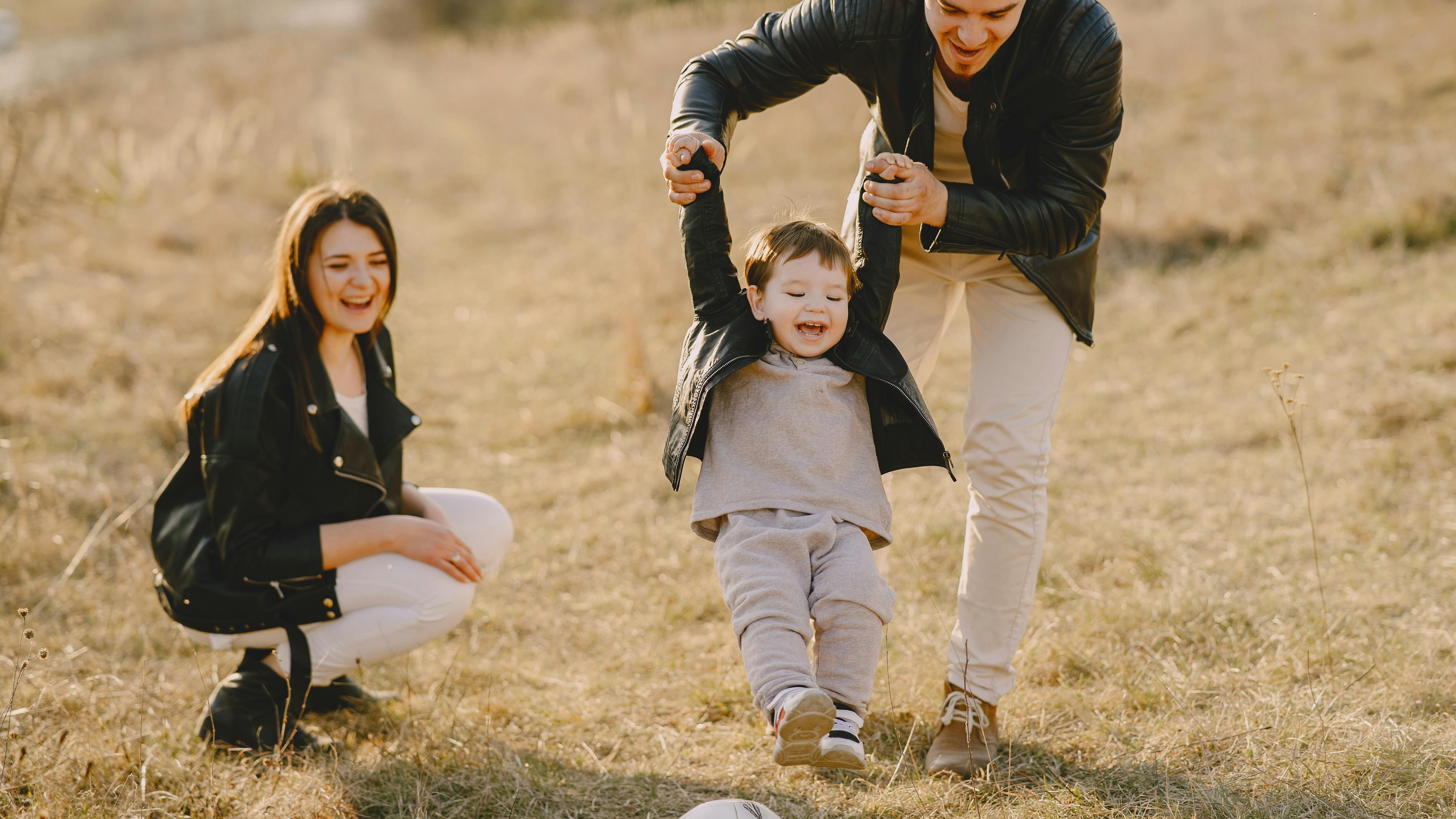 Joyful family blowing bubbles in sunny park, debt-free family tips.