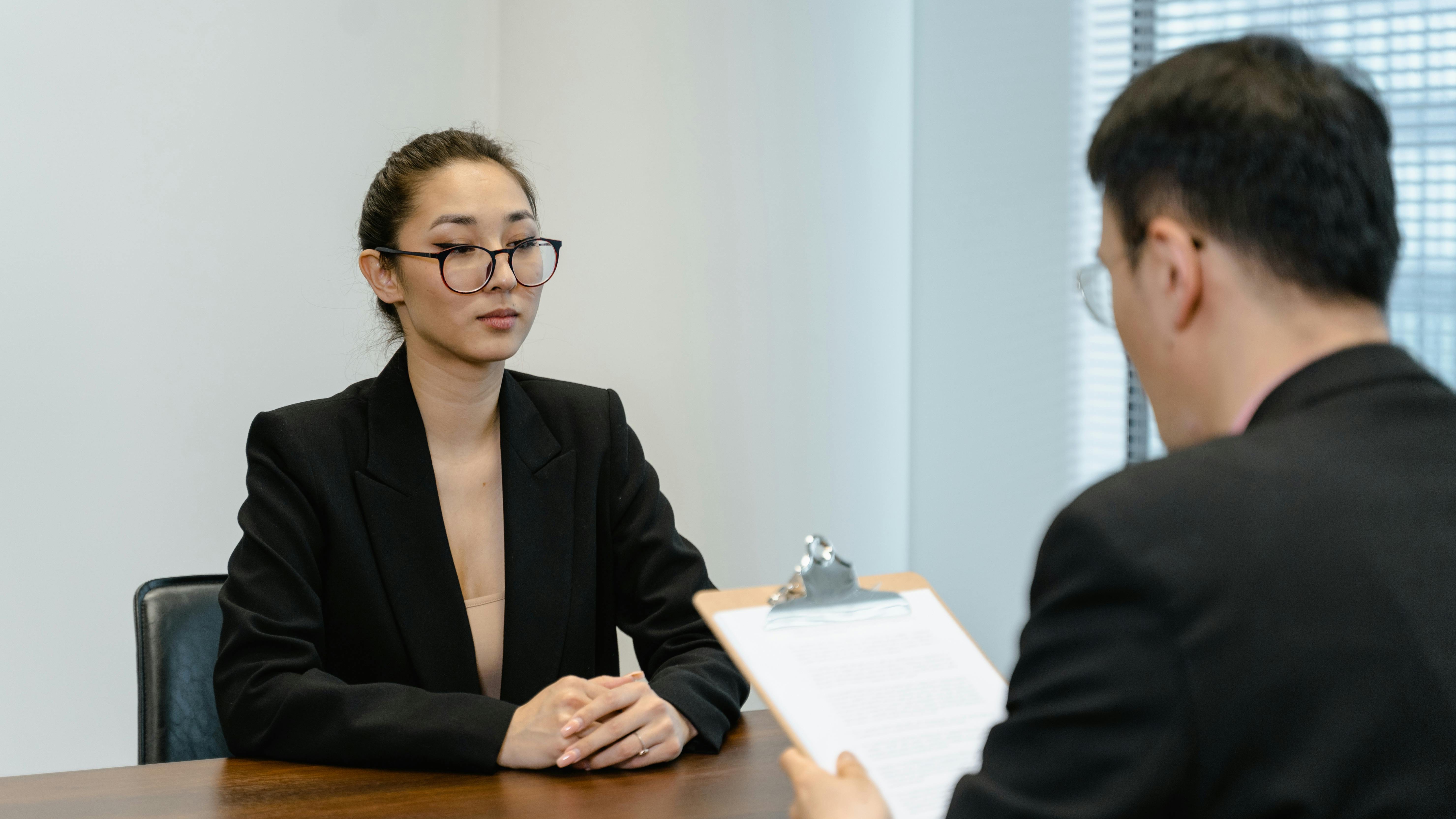 Professional setting showing hands at a job interview with resume.