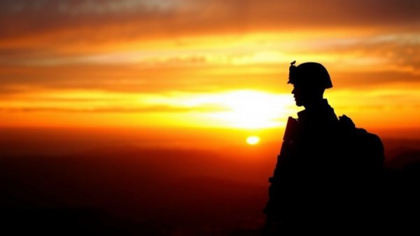 Silhouette of soldier transitioning to civilian life at sunset.