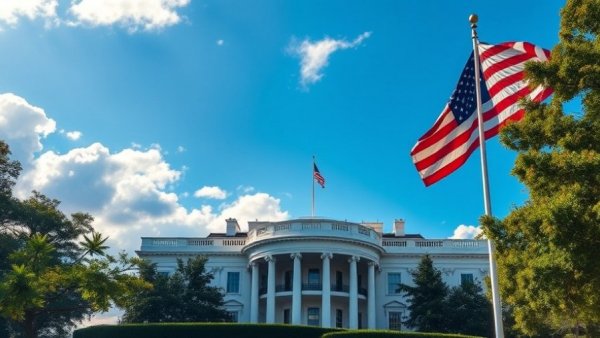 White House under clear blue skies with American flag.