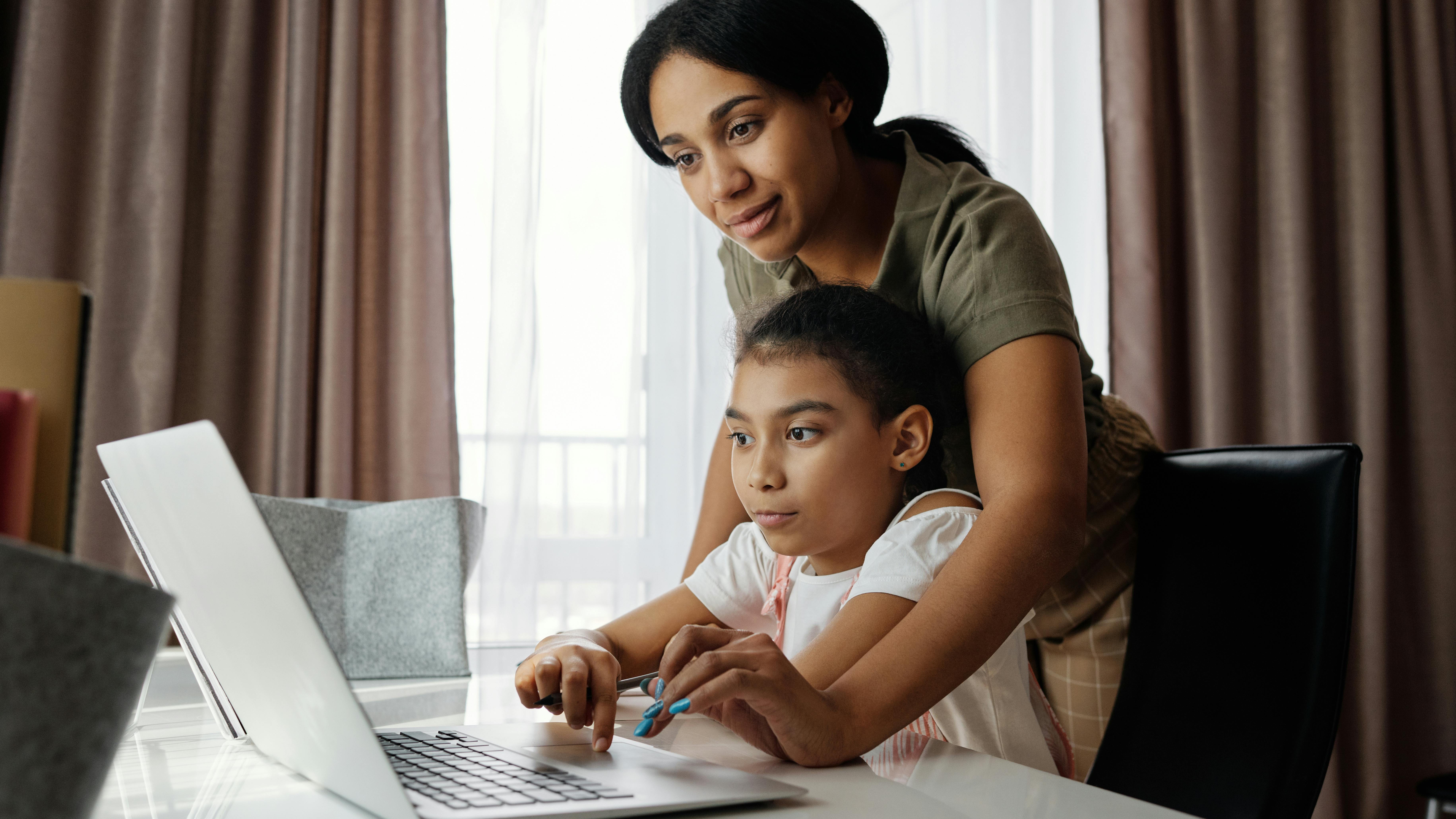 Adult assisting children with homeschooling tips at home.