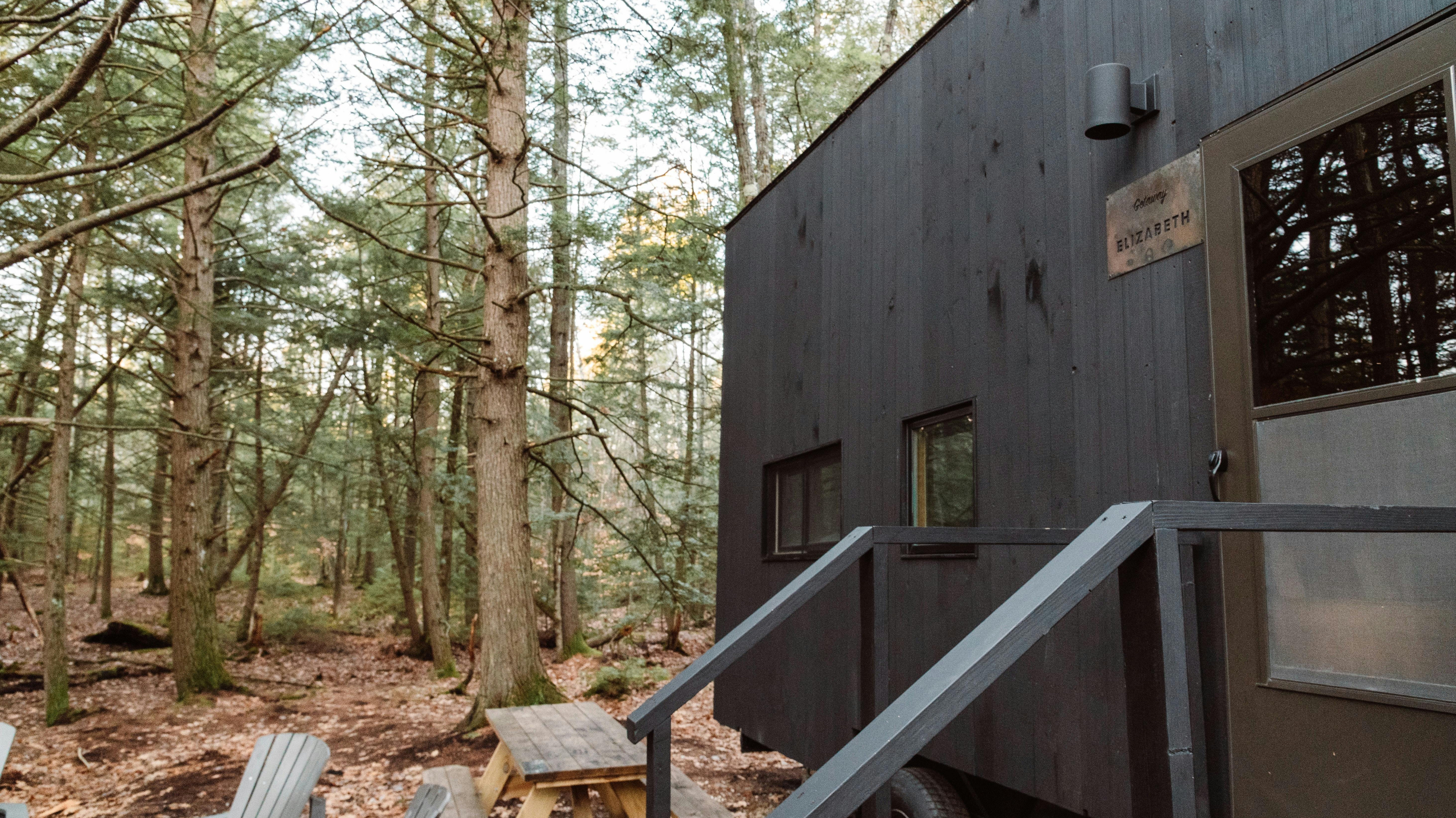 Eco-friendly off-grid tiny home in nature with mountains.