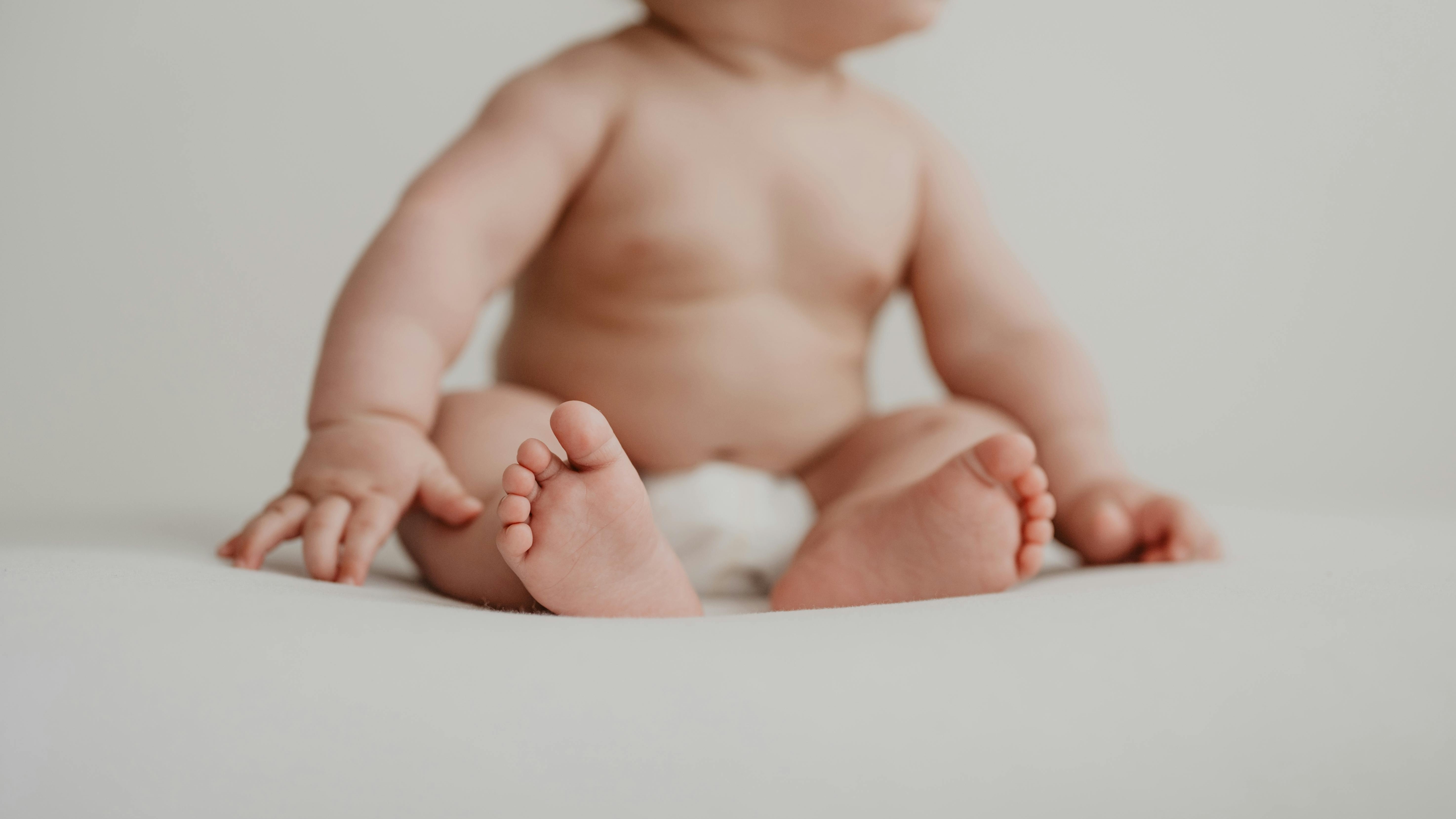 Parents changing baby's diaper with wipes, caring environment.