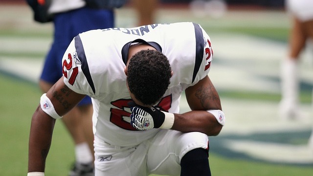 Man speaking at a podium at NFL Salute to Service Award event.