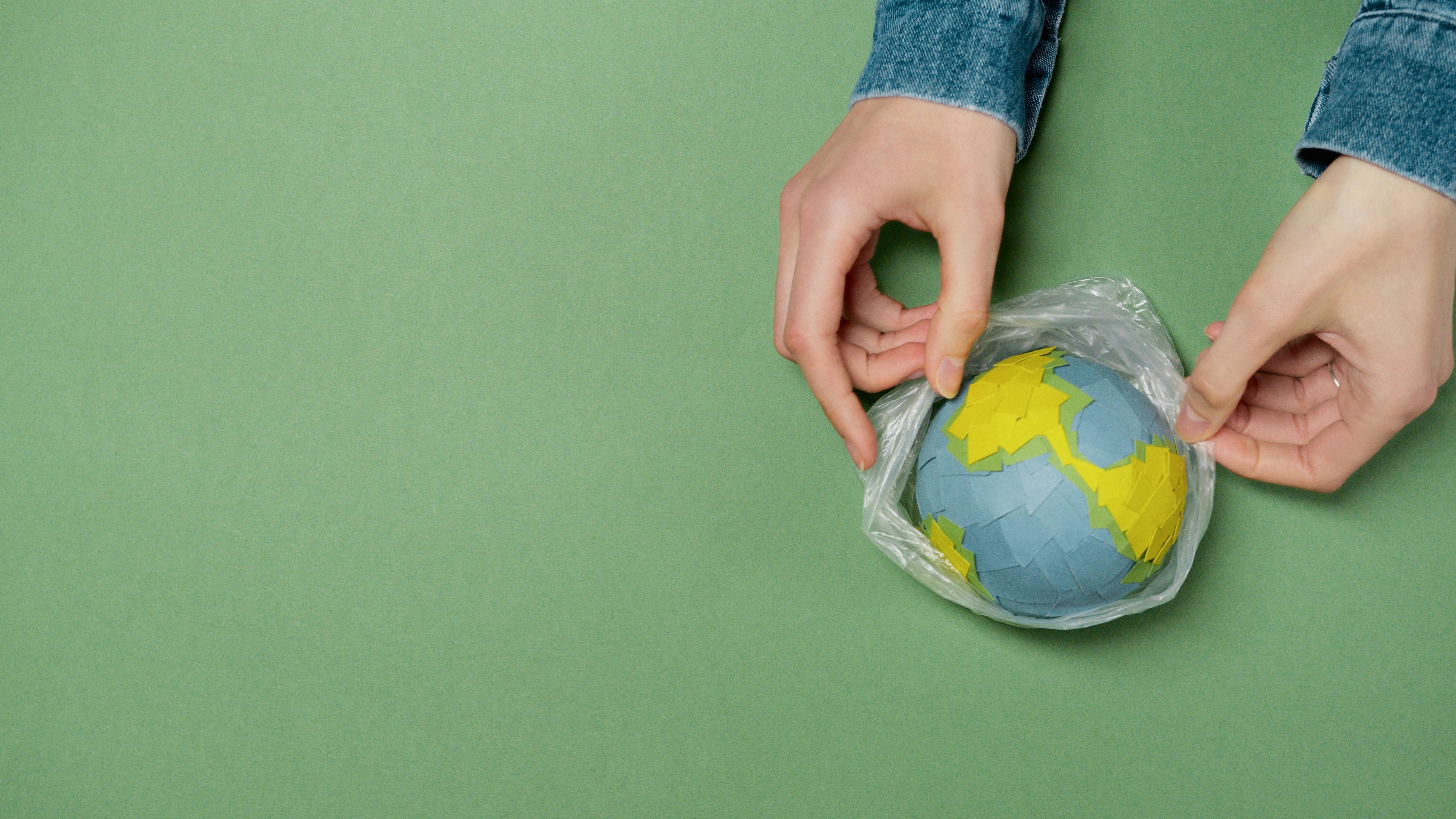 Earth Day Omaha 2026 cooperation symbolized with handmade globe exchange.