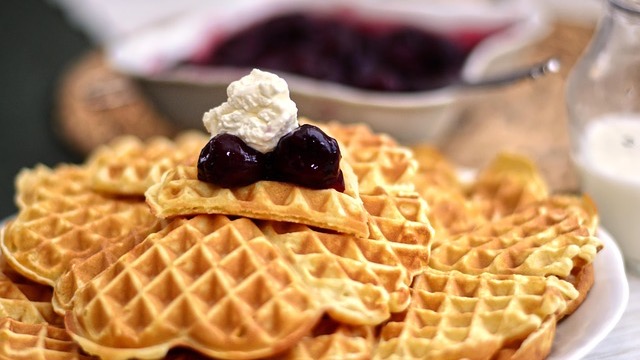 Healthy family meals: blueberry waffles with syrup and juice.