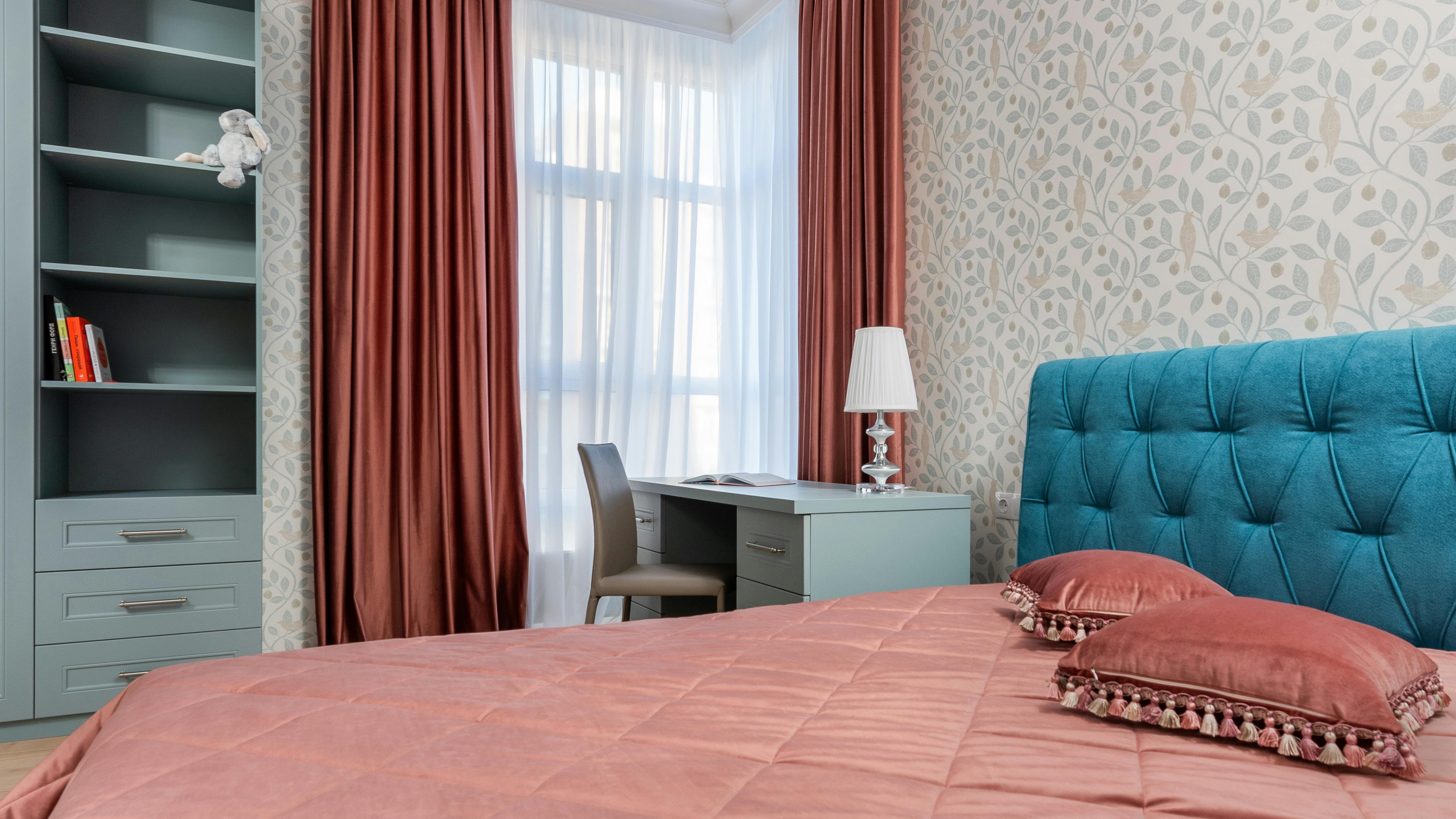 Trendy 2026 bedroom with botanical wallpaper and plush bedding.