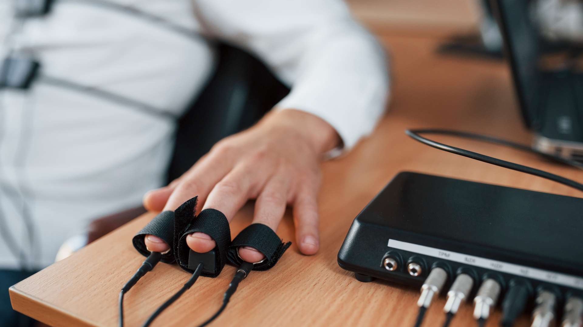 Man taking a polygraph test analyzing data on a laptop related to the Employee Polygraph Protection Act.