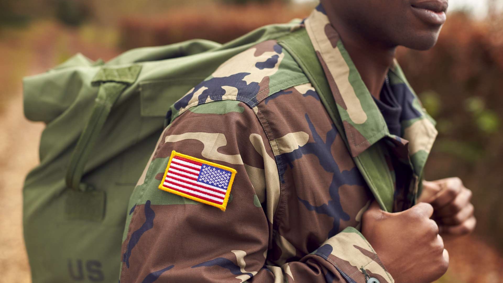 Military commitment uniforms: soldier in camo and beret holding rifle.