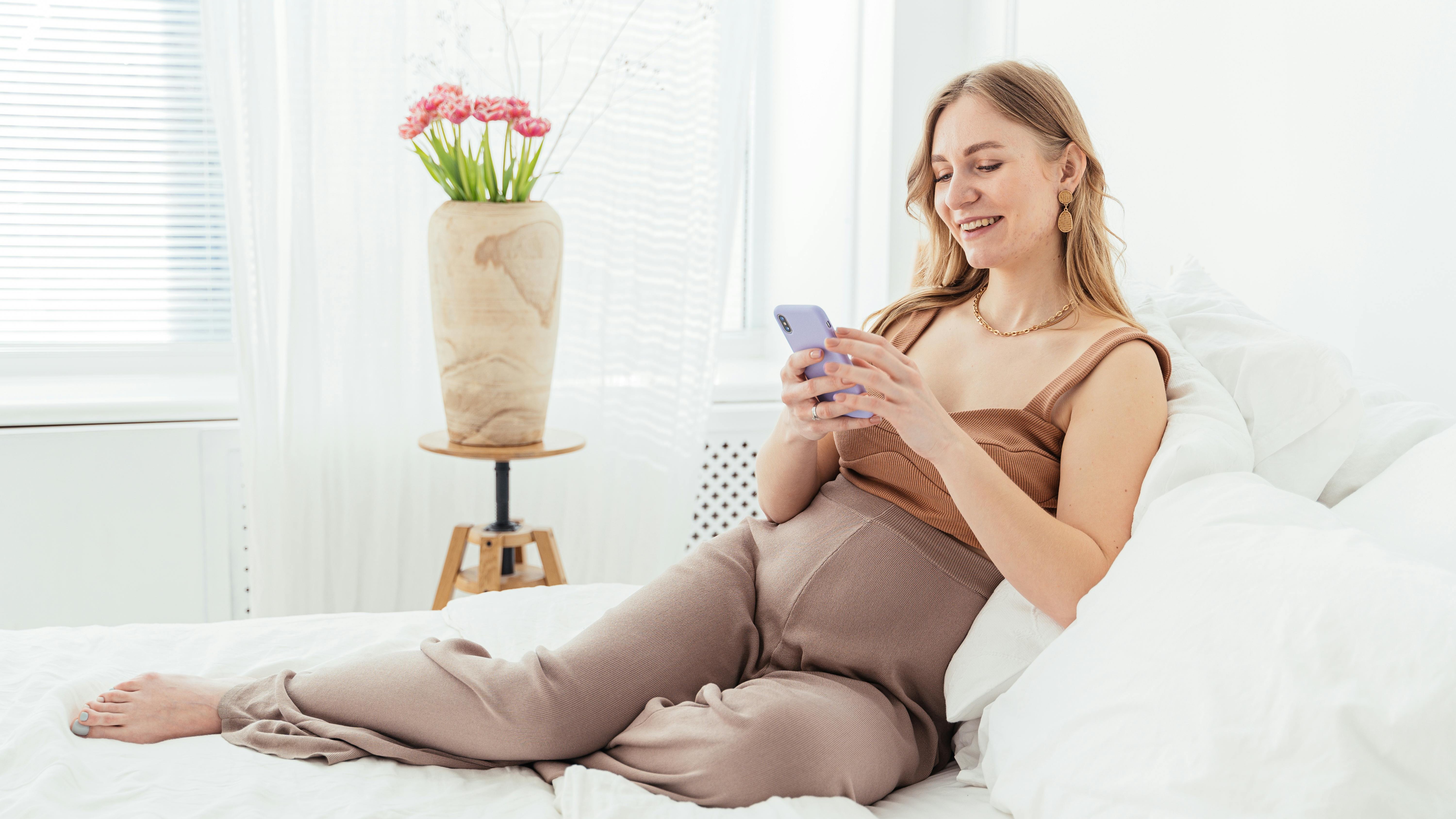 Pregnant woman with a supportive pillow and dog, best pregnancy pillows.