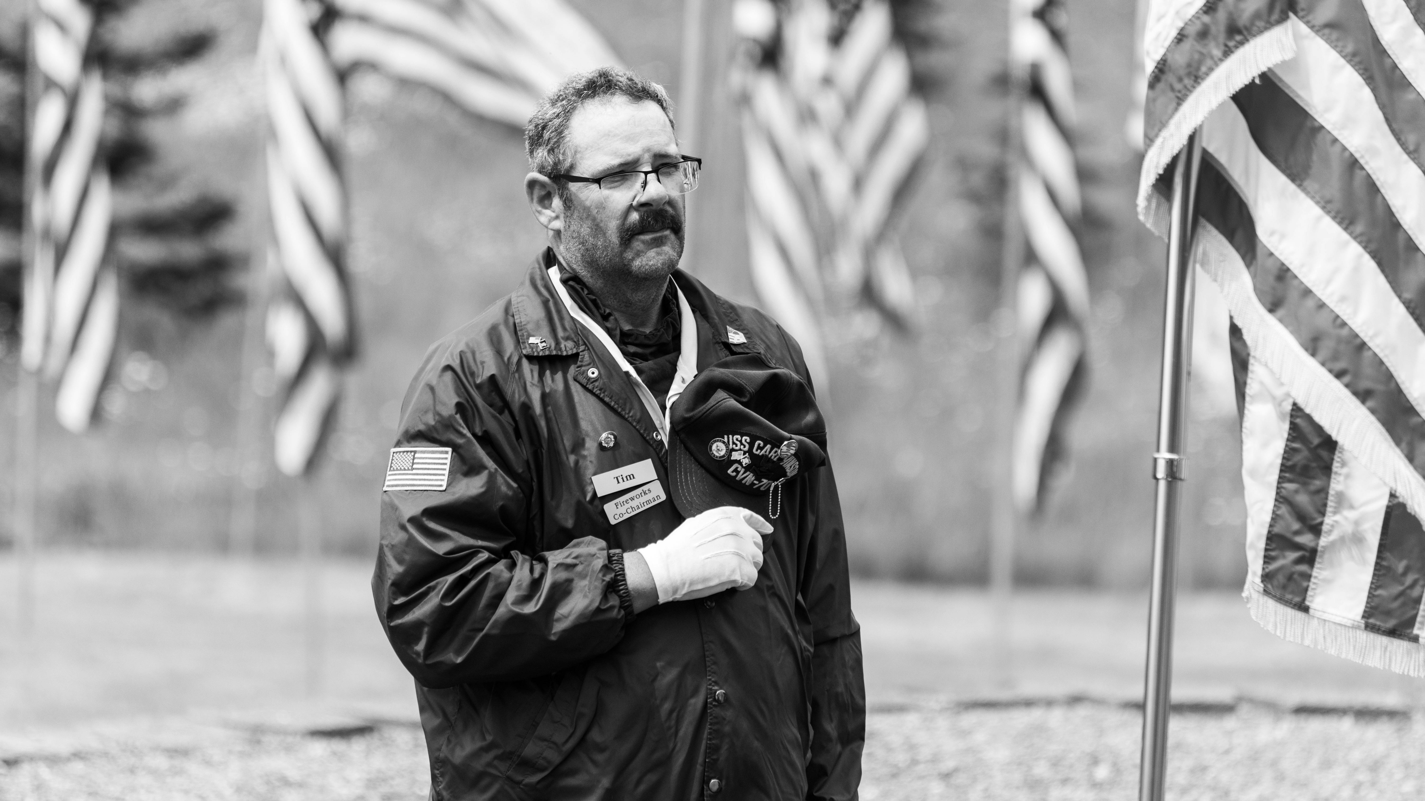 Ceremonial guard marching at memorial with floral tribute.