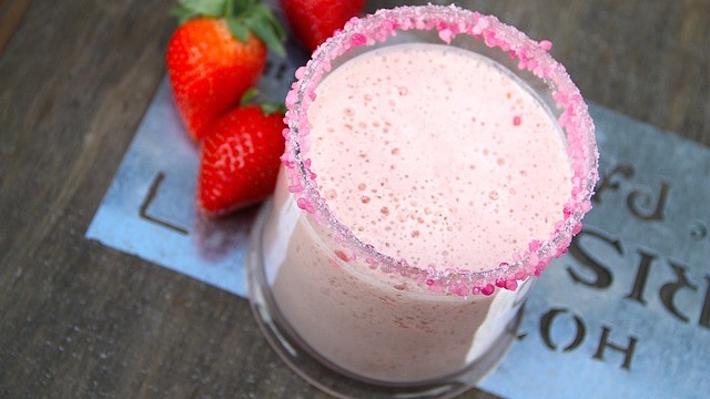 Delicious purple pregnancy smoothie with pink straw in a glass.