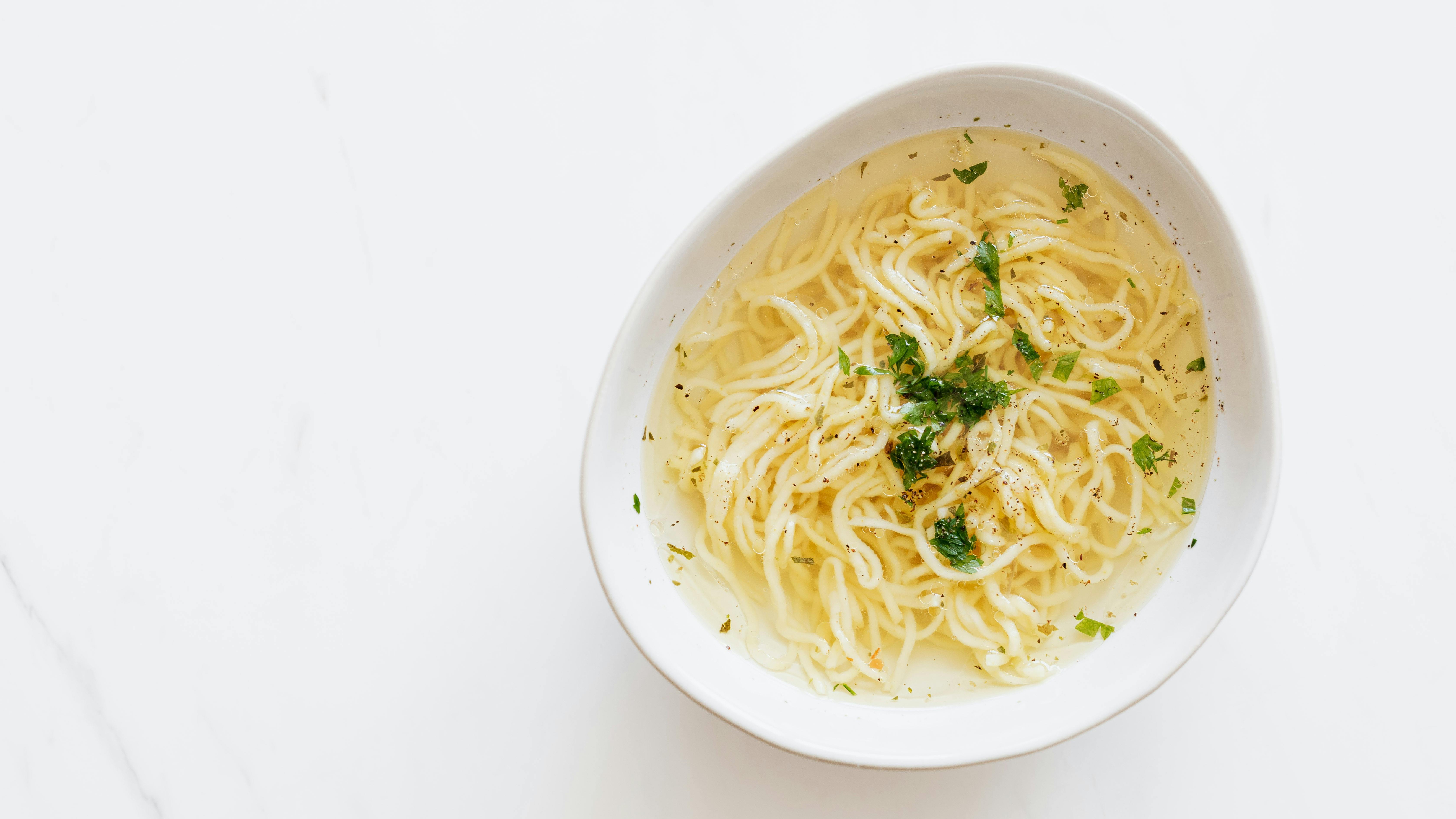 Hearty creamy chicken noodle soup recipe, overhead view.