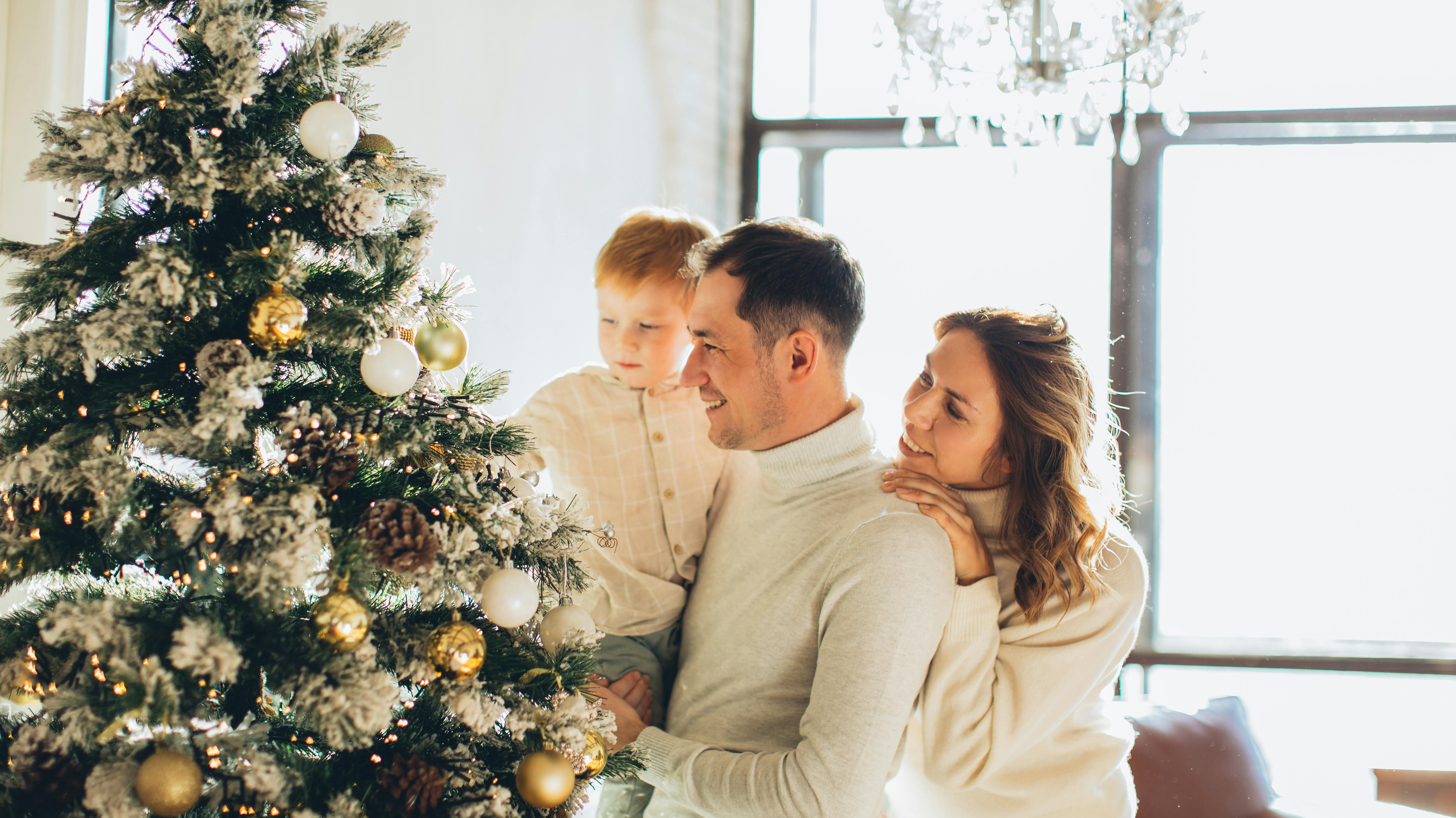 Woman dealing with mom guilt during holidays by Christmas tree.