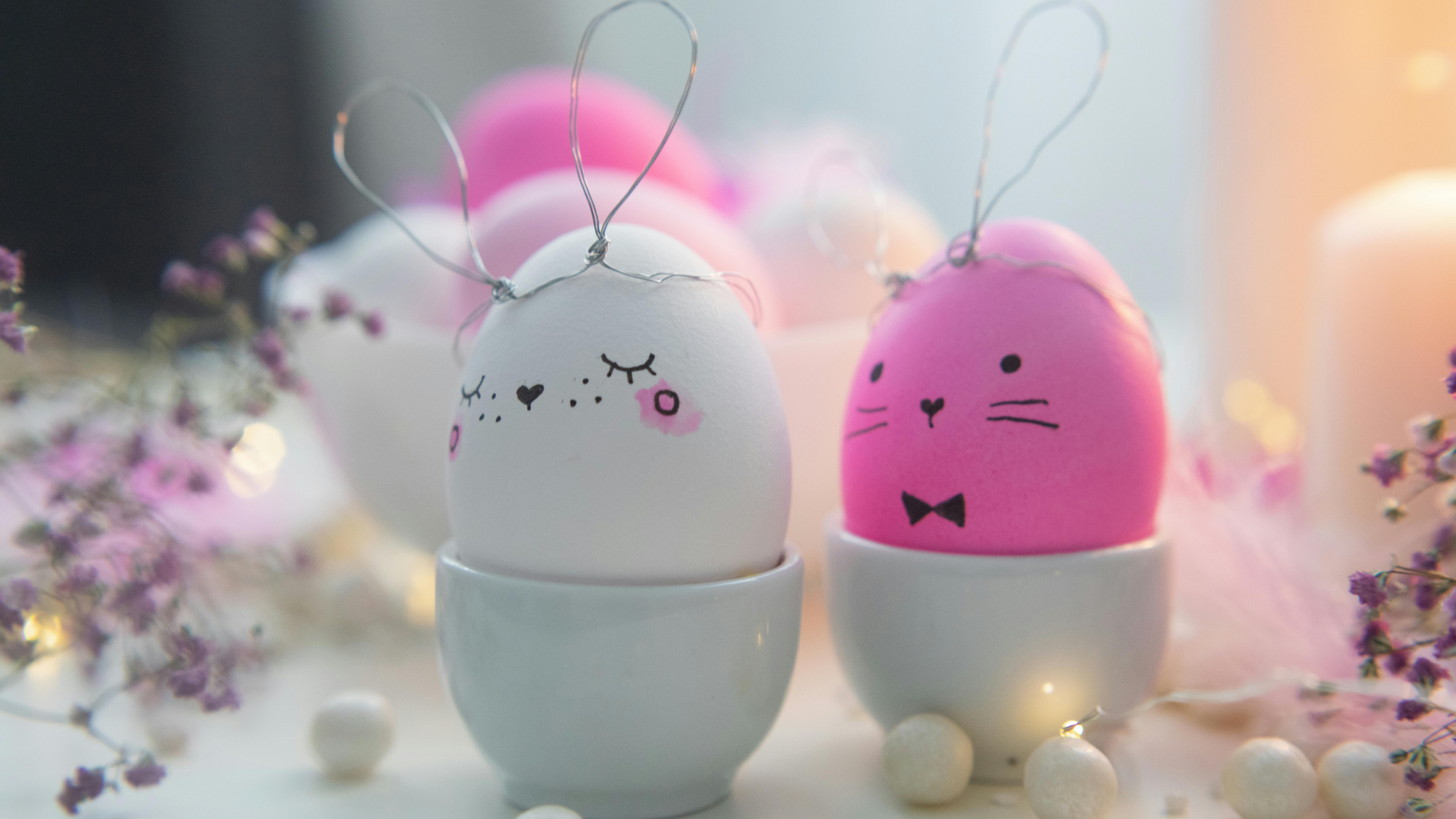Child doing easy Easter crafts with pink bunny paper and pastel eggs.