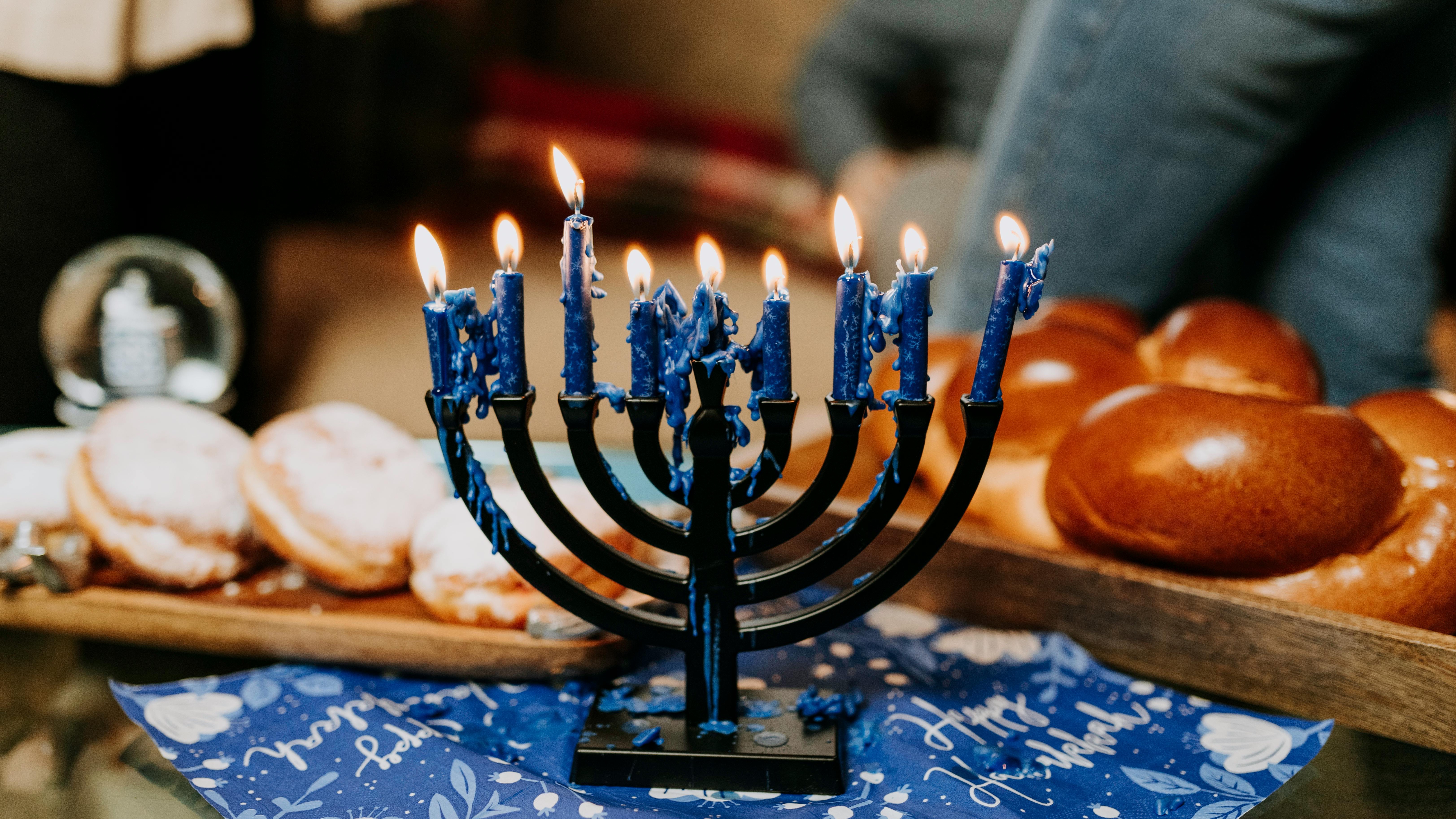 Children lighting menorah, celebrating with kid-friendly Hanukkah songs.
