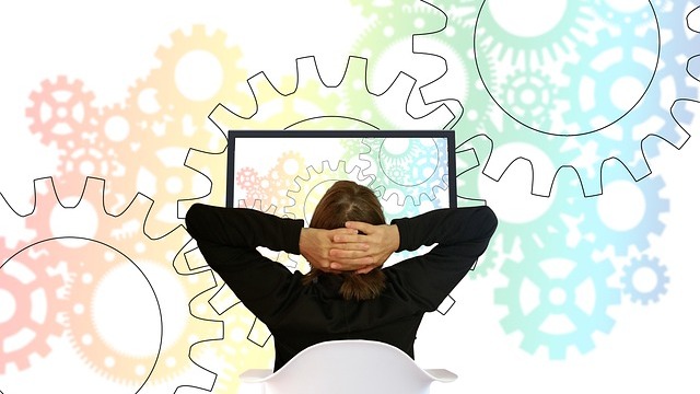 Young woman using a laptop in a futuristic data center environment, future of work automation.