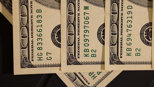 Stressed woman addressing workplace stress with dim office lighting.