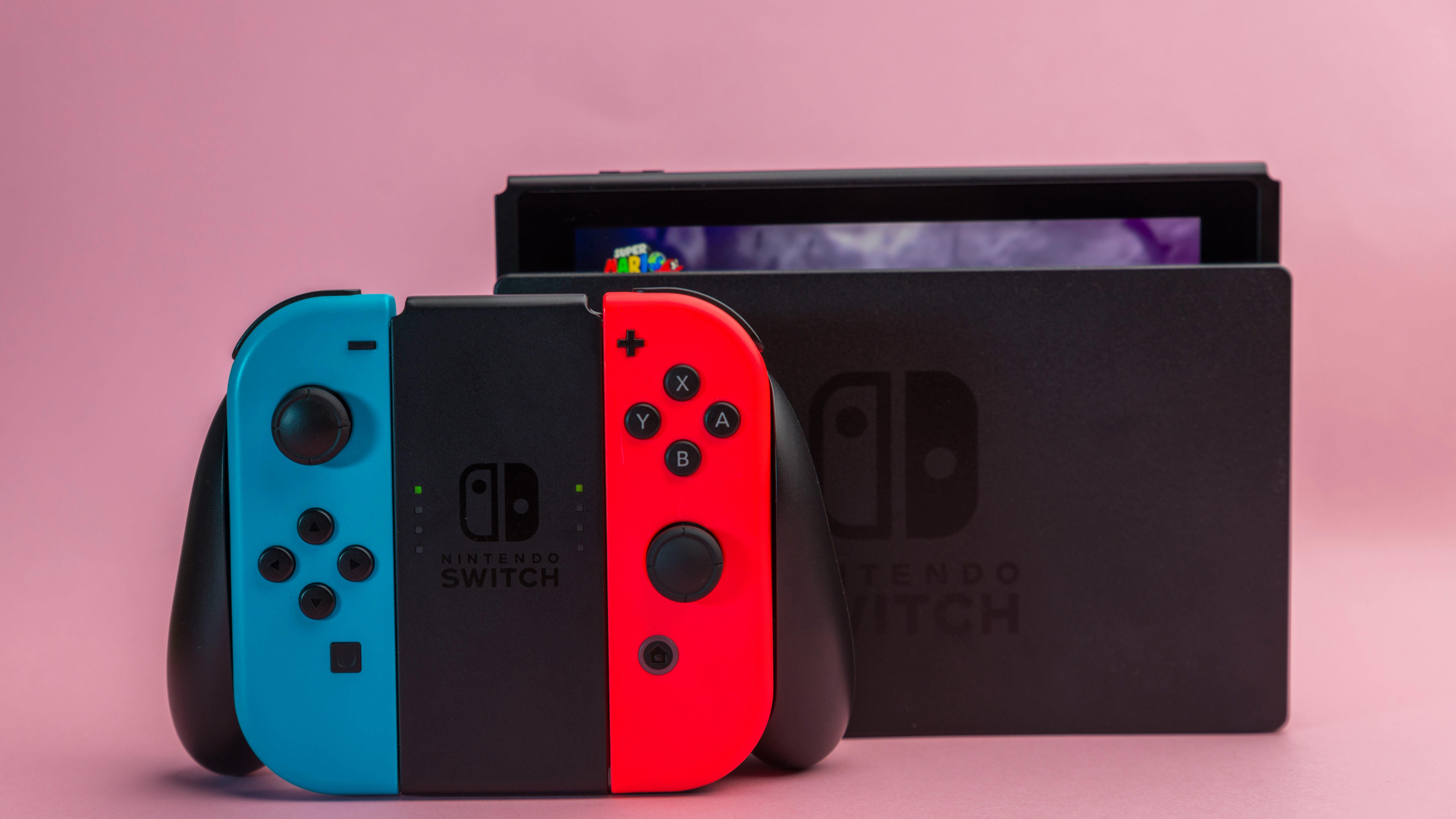 Nintendo Switch 2 console with Joy-Cons against a red background.