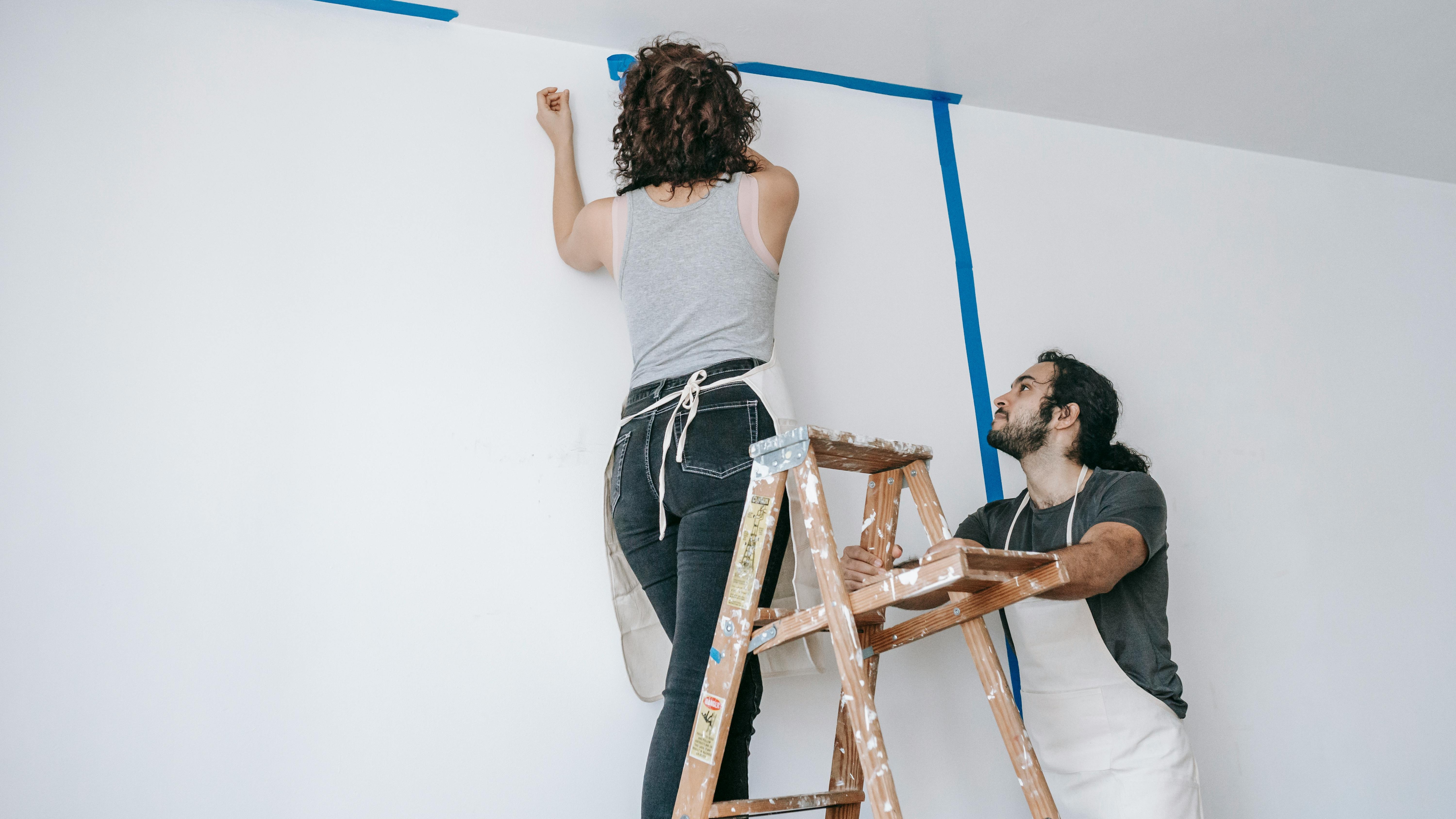 How to prepare a room for paint: Young woman rolling up carpet