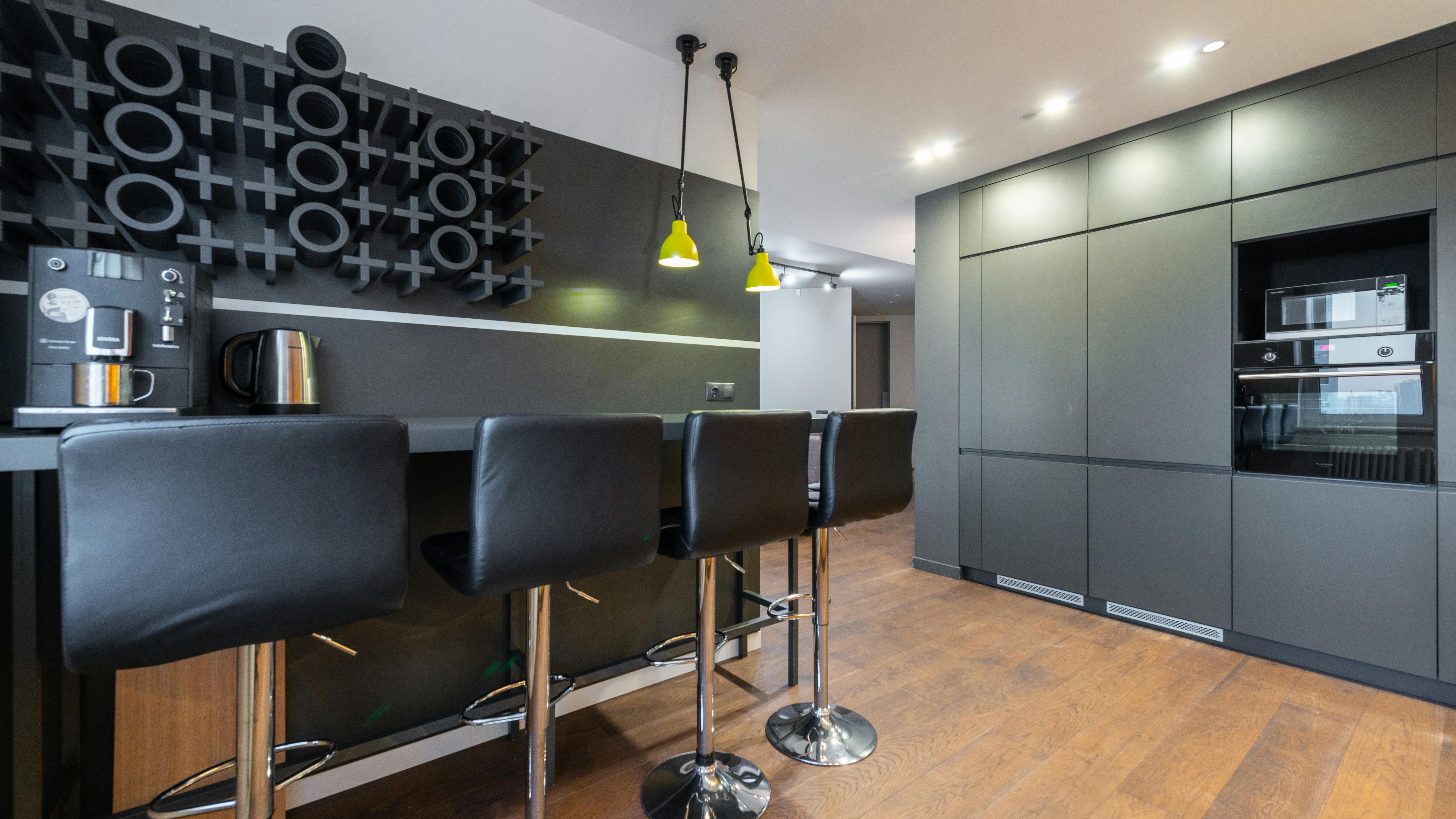 Modern kitchen with dark green cabinets and creative paint colors.