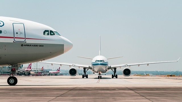 Mother and child watching planes, airport terminal scene, minimize jet lag for kids.