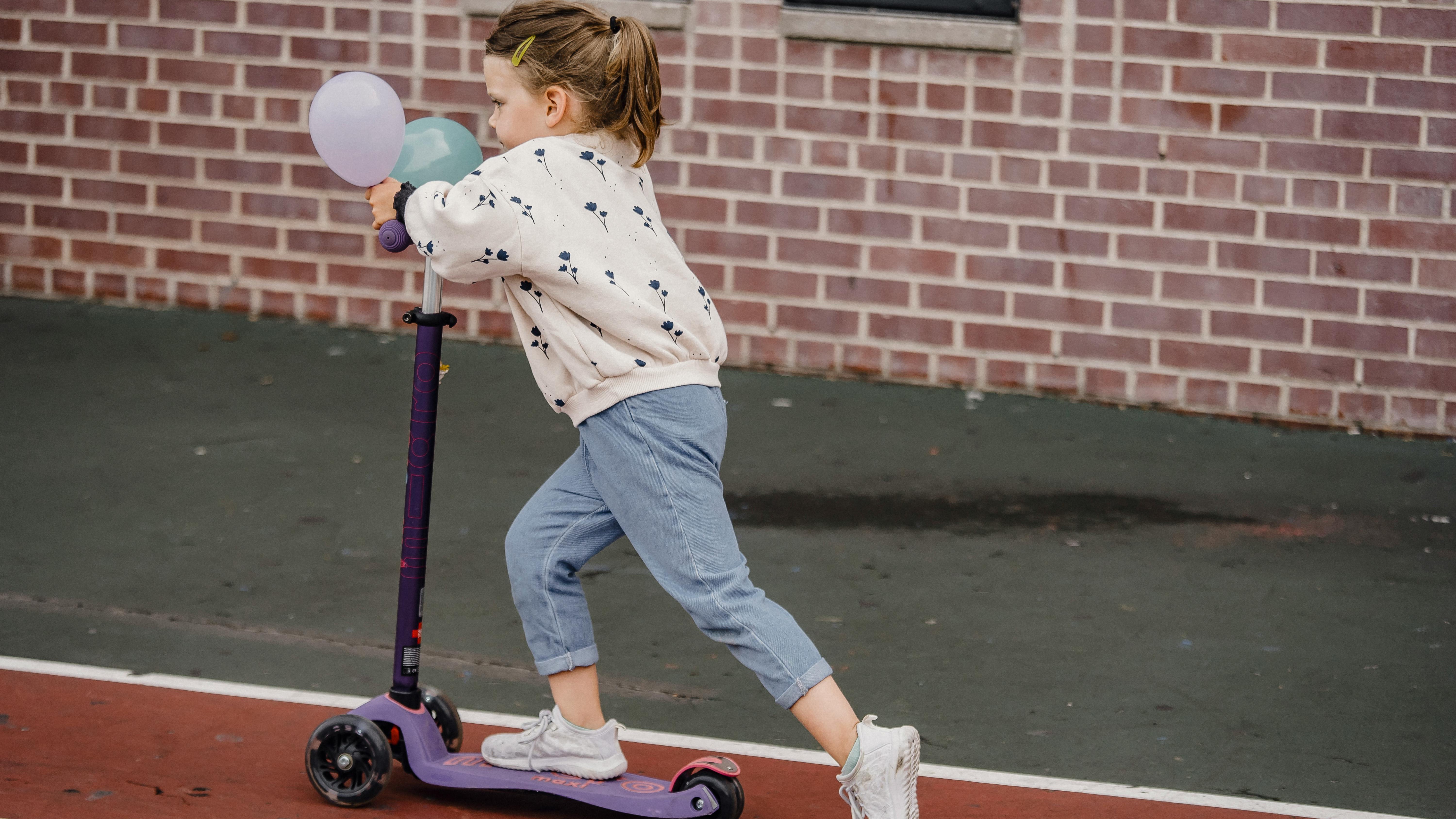 Child using scooter board indoors for sensory input.