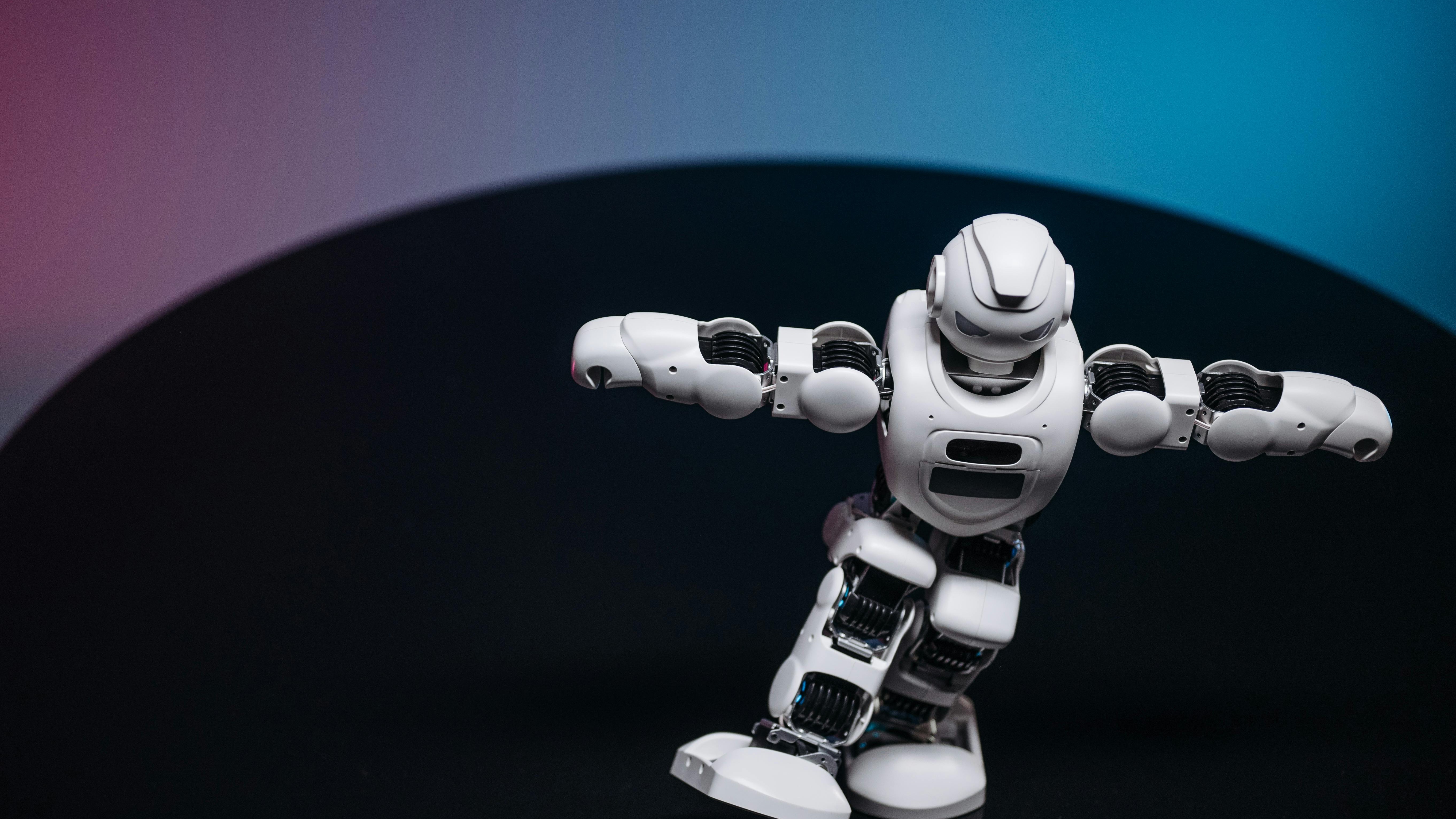 Smiling humanoid robot waving in a tech workshop