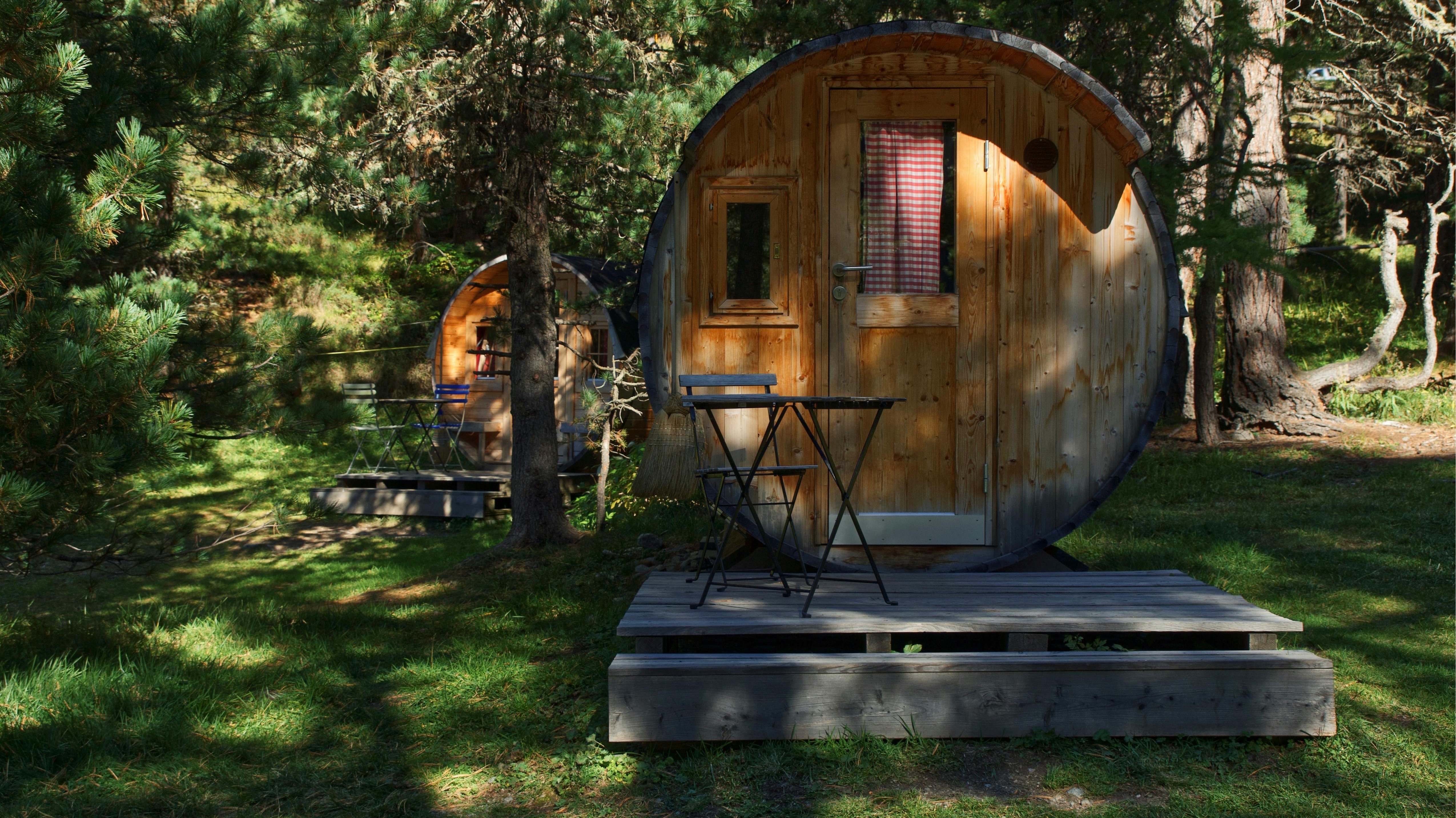 Cozy trolley car interior transformed into a tiny home with a bed and kitchen.