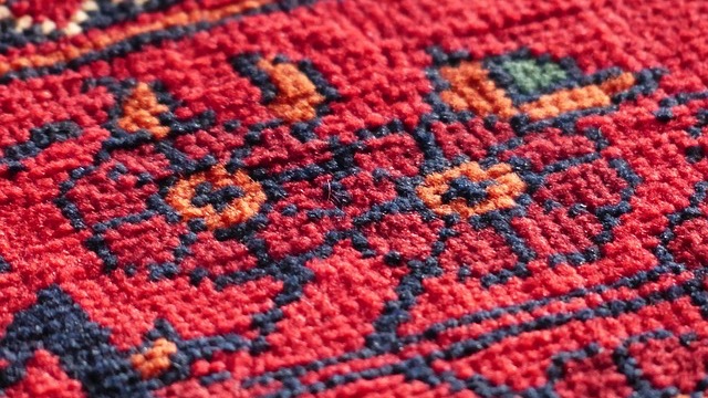 Modern living room with beige sofa, outdated carpet colors, and wooden stairs.