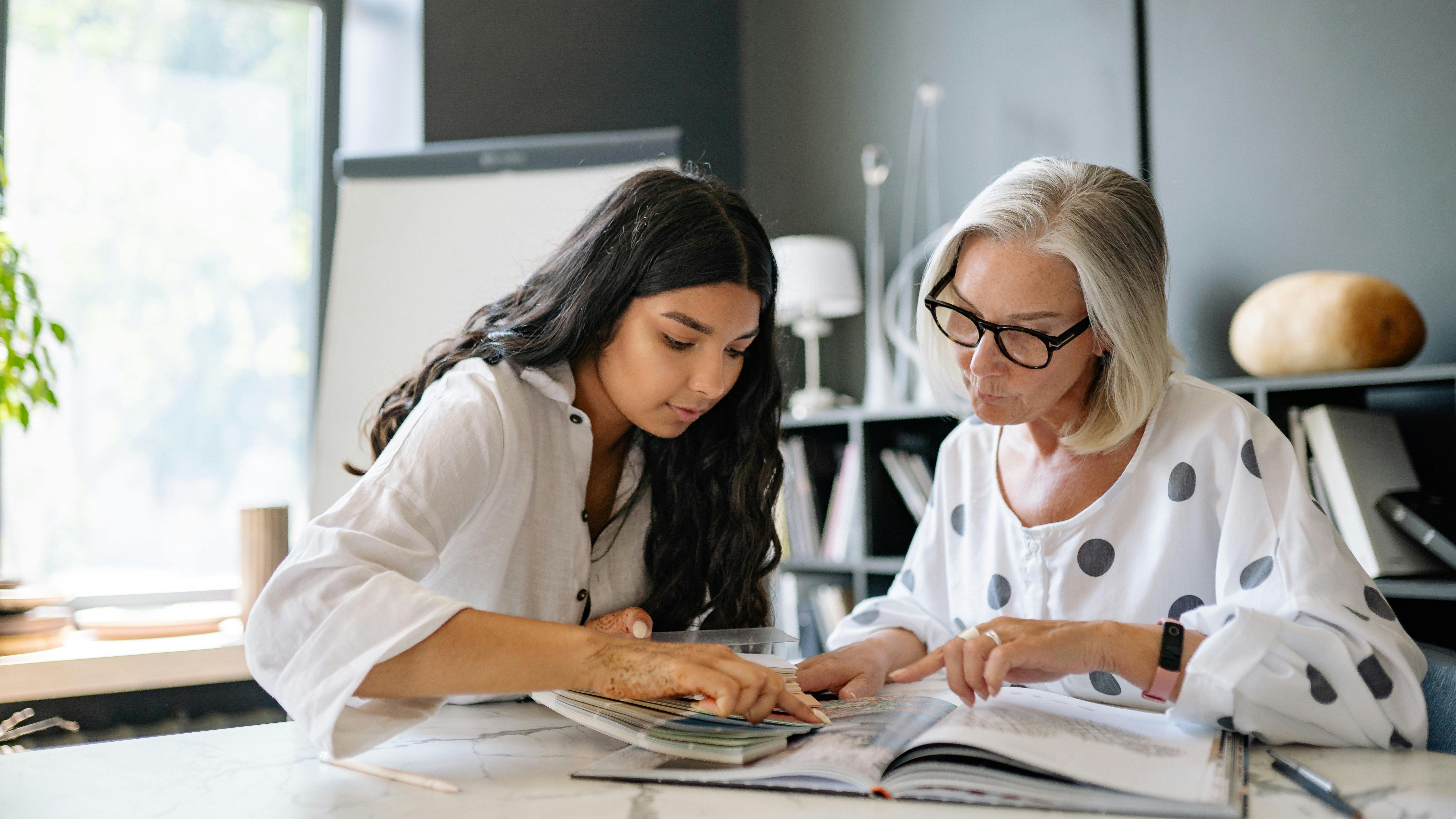 Talent management: experienced worker mentoring apprentice in industrial setting.