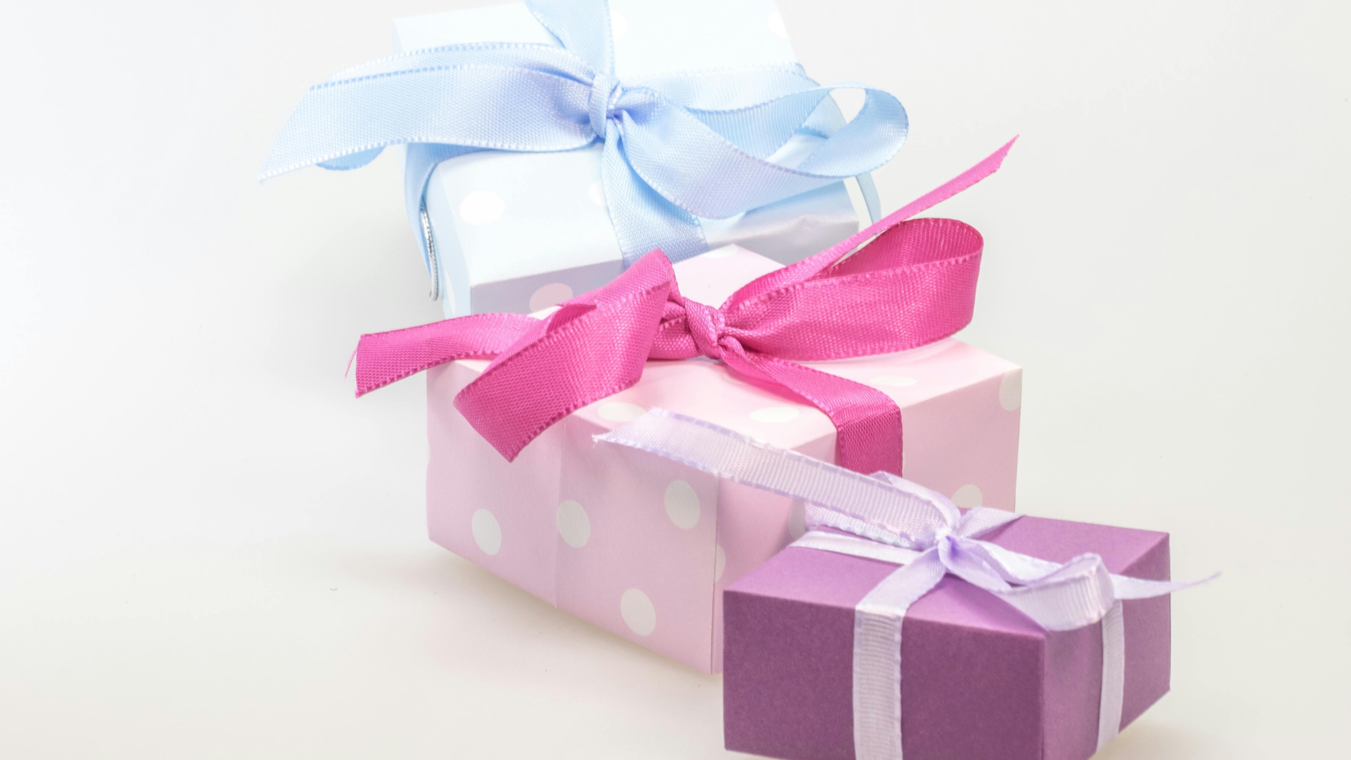 Gift under $25 wrapped with white and gold ribbon.