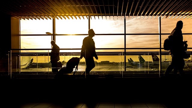 Travelers in line at airport, business travel TSA workers pay context.
