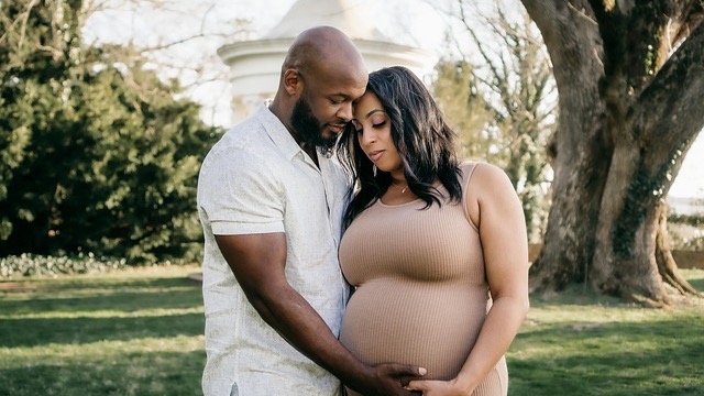 Pregnant woman holding belly related to vaginal discharge during pregnancy.